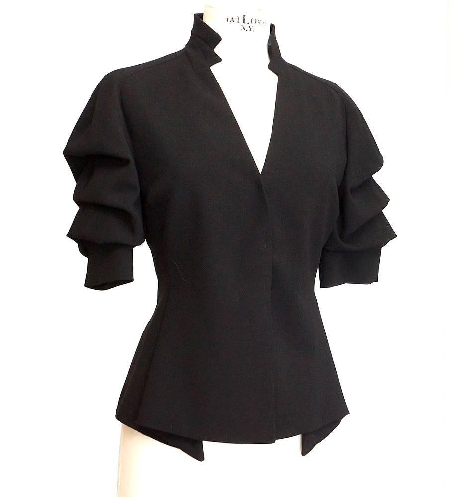 Guaranteed authentic Akris striking jet black skirt suit.  
Exquisitely designed jacket with sleeves to elbow.
Sleeves have 3 gentle folds creating a cascading effect.
A wide cuff with snaps at the elbow.
Modified mandarin collar with design detail