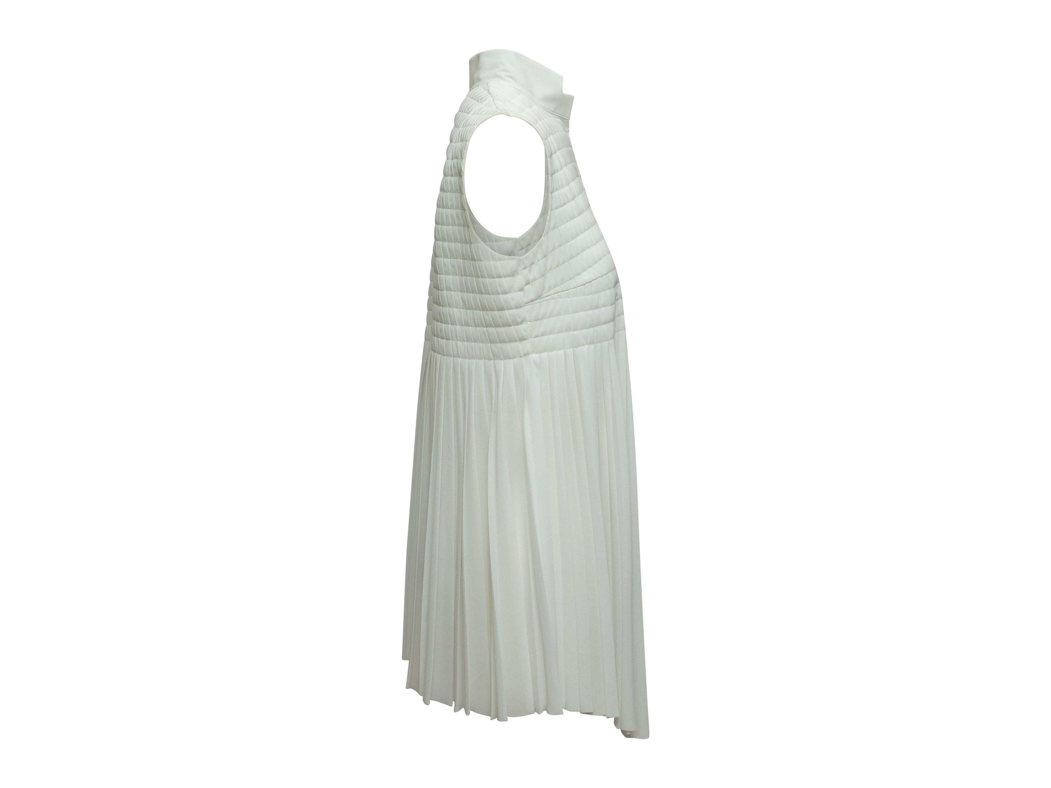Product details: White sleeveless pleated top by Akris. V-neck. Asymmetrical hem. 34