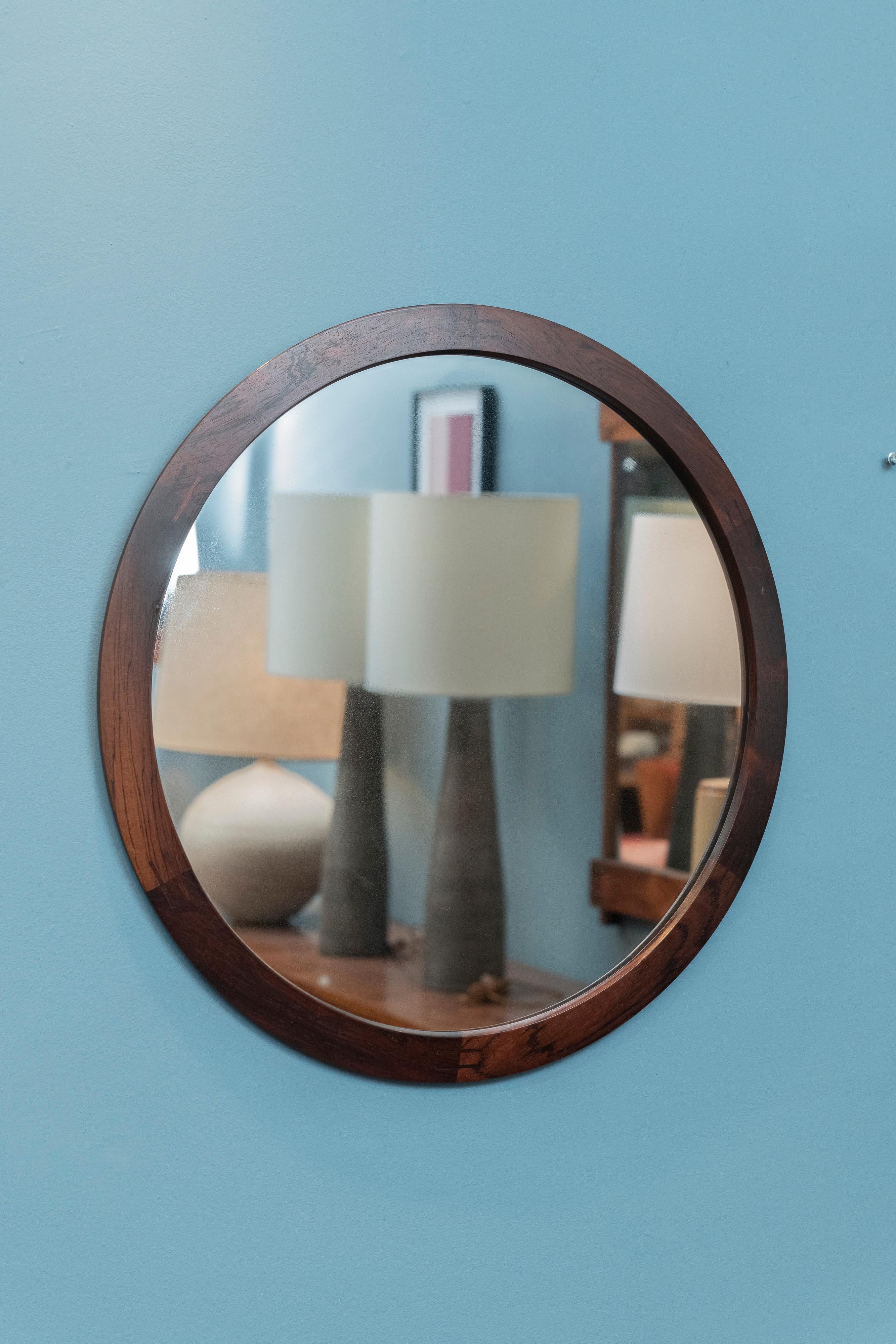 Aksel Kjersgaard design rosewood round wall mirror, model 280. Rare mirror in beautiful rosewood with inlaid joinery in very good original condition. Manufacturer's stamp on the back, produced by Odder of Denmark. It is ready to install and enjoy.