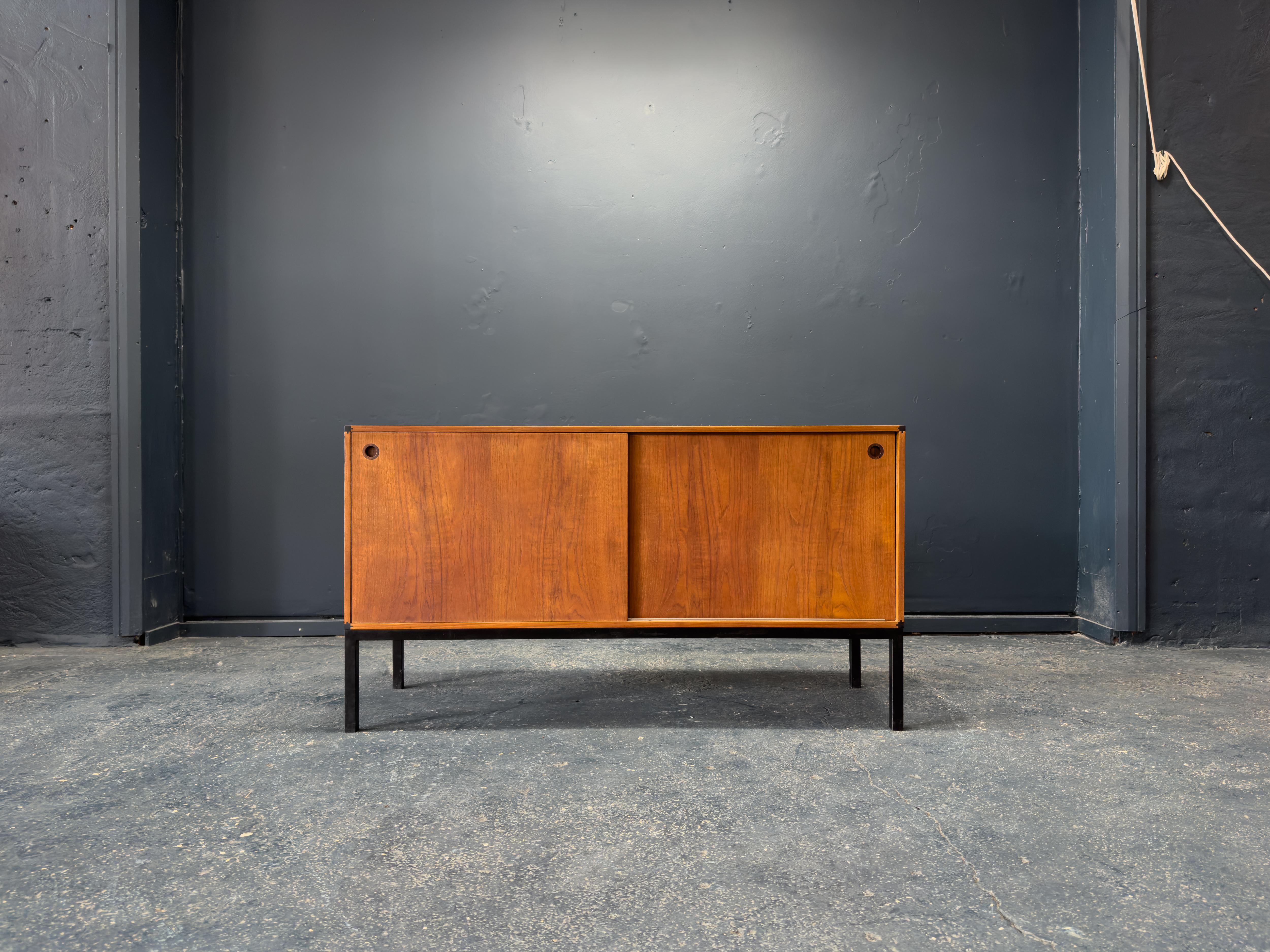 Ce superbe buffet d'Aksel Kjersgaard illustre le savoir-faire méticuleux et l'esthétique raffinée du design moderne danois. Construite en teck richement figuré, la pièce est rehaussée littéralement et stylistiquement par ses élégants pieds en métal