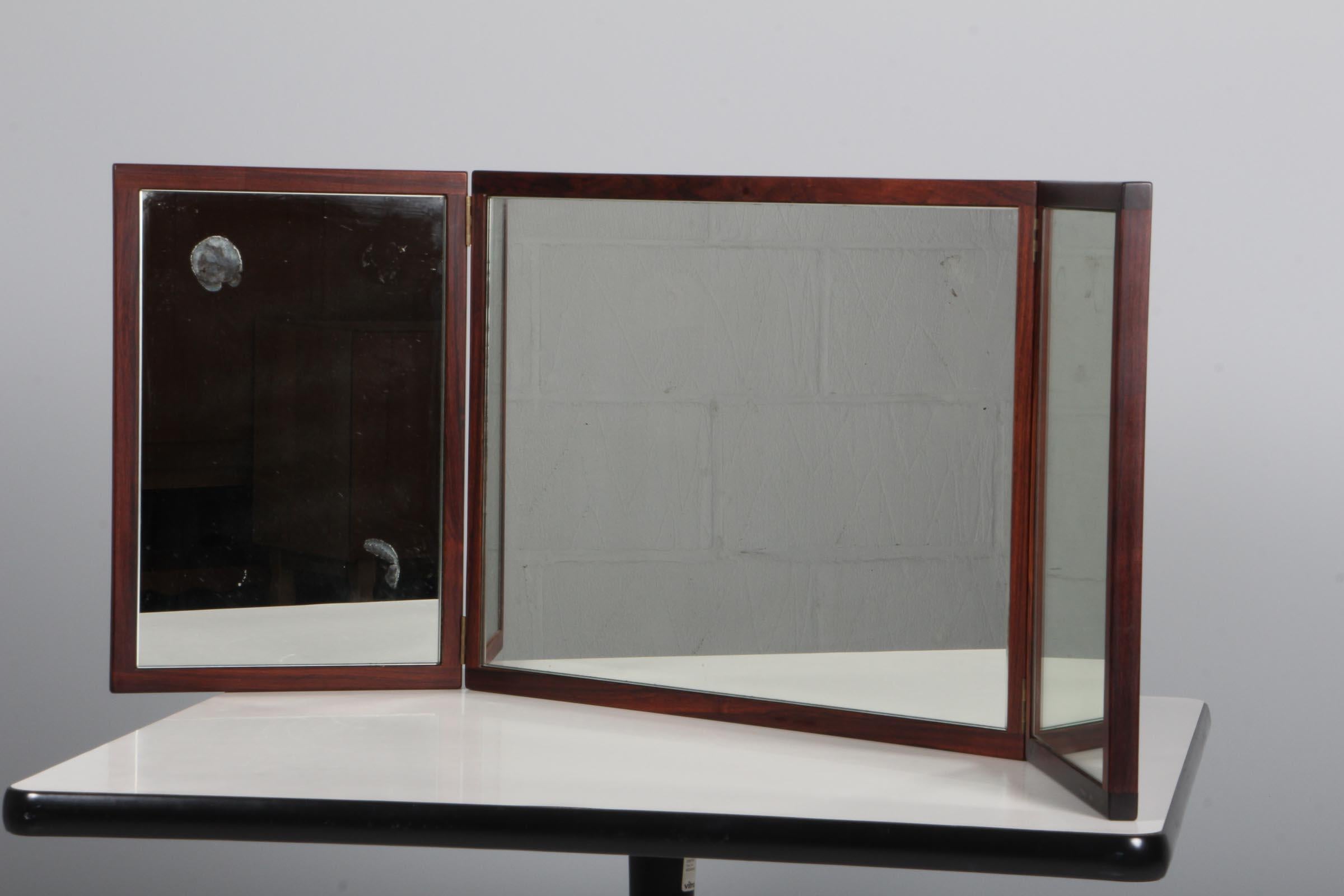 Aksel Kjersgaard. Klappbarer Spiegel aus Palisanderholz, Dänemark, 1960er Jahre.

Maße: H. 43 B. 58/116 T. 45.