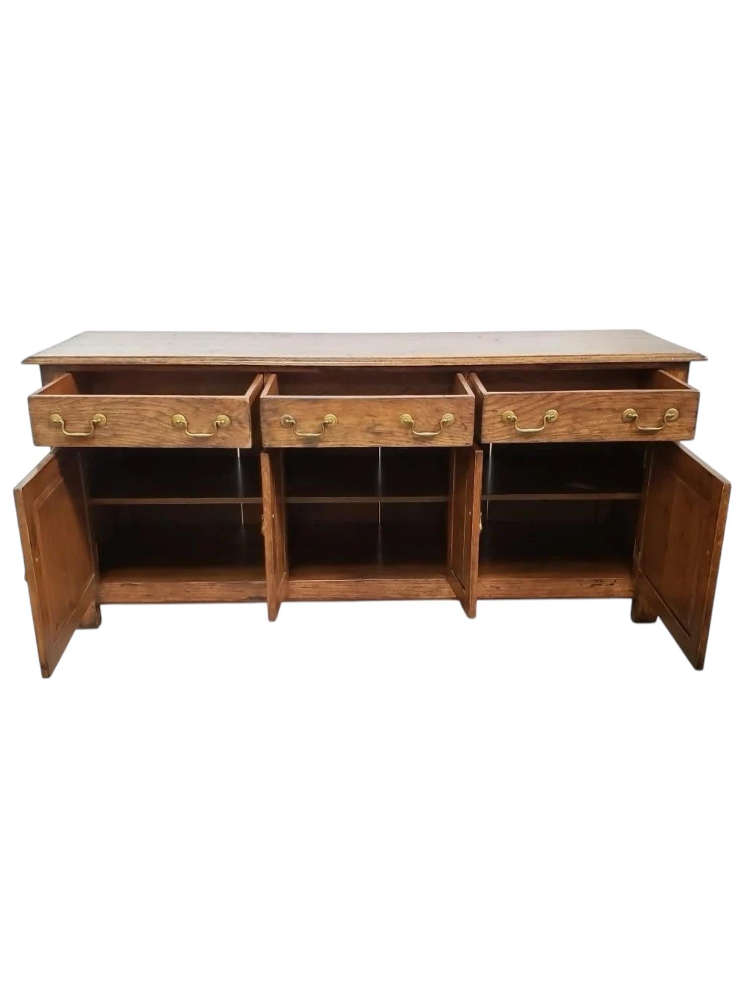 Un'elegante credenza/armadio in quercia disegnata per John Hall e firmata dal famoso artigiano Al. Frilot. Questo pezzo sapientemente costruito presenta ricche venature di Oak, linee pulite e dettagli raffinati che ne evidenziano l'influenza di metà