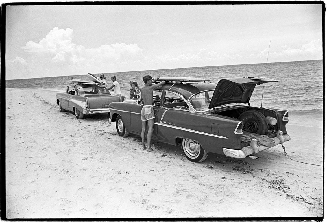 Al Satterwhite Black and White Photograph - Surfer Kids loading surf boards