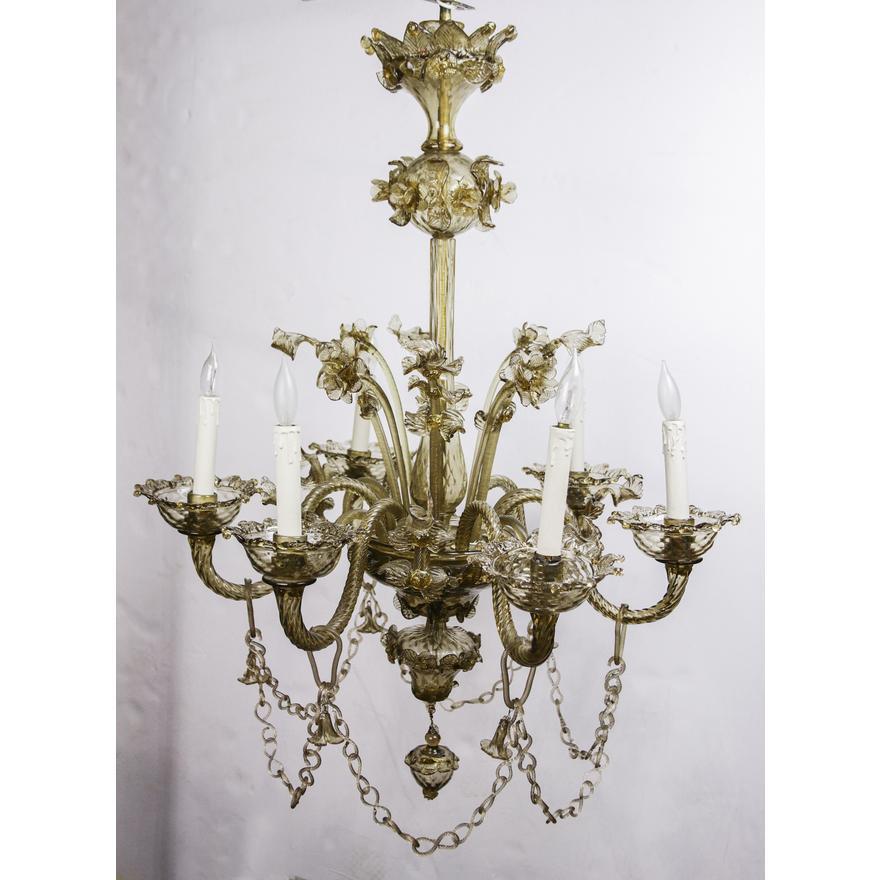 Magnifique lustre en verre soufflé à la main de Murano, datant du début du 20e siècle, composé de 6 bras et de 6 branches fleuries émanant d'un plat central en verre soufflé à la main. Un total de  6 douilles à base candélabre. Un plafonnier est