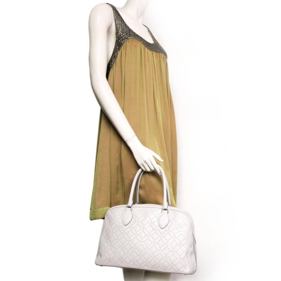 Alaia Arabesque bag in in pearl gray smooth lamb leather. It has silver metal studs.

Worn by hand or on shoulder.

The interior is lined with slightly aged pink leather and has 2 pockets including one zipped.

It is in very good condition and has