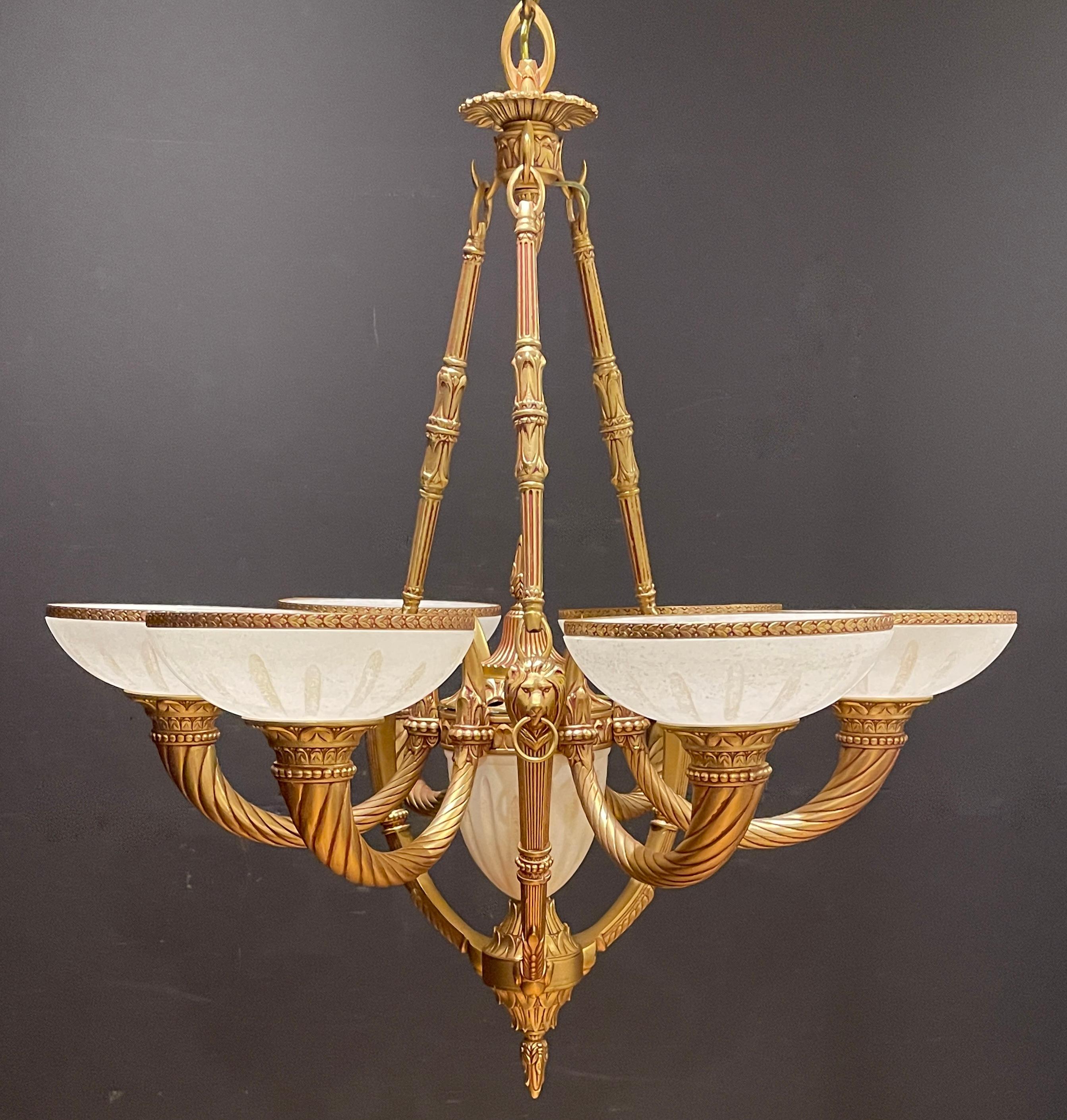 Beautiful vintage alabaster and bronze chandelier. Warm white fitted alabaster half sphere shades with carved flutes and bronze ring. Center body with three upright supports and lion heads.