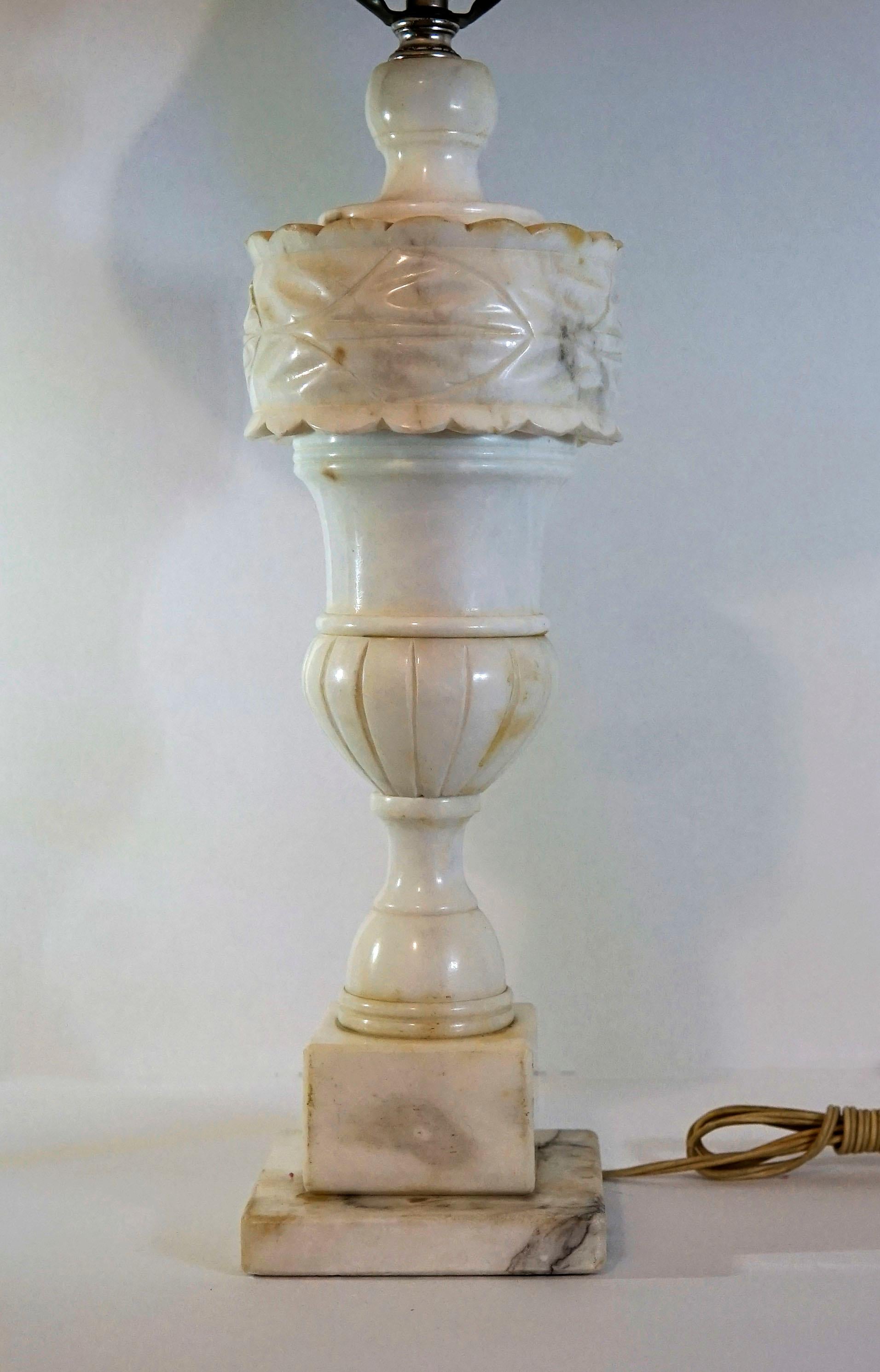 This alabaster lamp is stunning, with its irregular veining and exquisite carving. It is antique Regency style hand carved alabaster from the late 19th Century.
The baluster form is surmounted by a carved drum-form cuff over an urn-form body. The