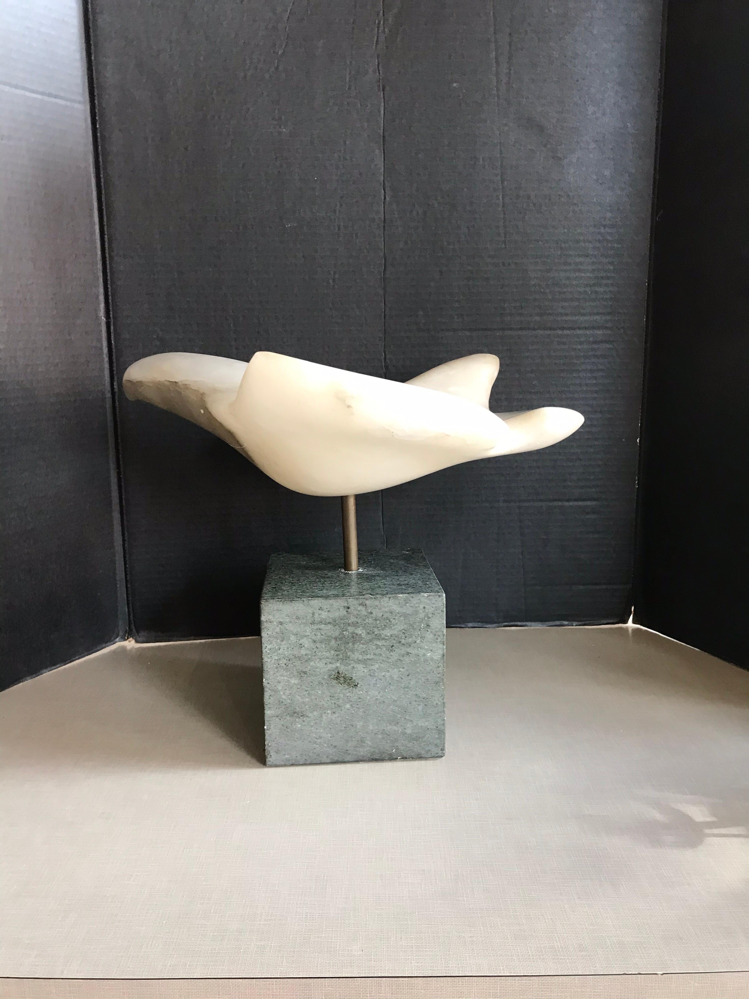 This is a large alabaster hand carved bird that is supported by a steel rod on a heavy marble stand. It was made in 1991 and signed by the artist Pile.