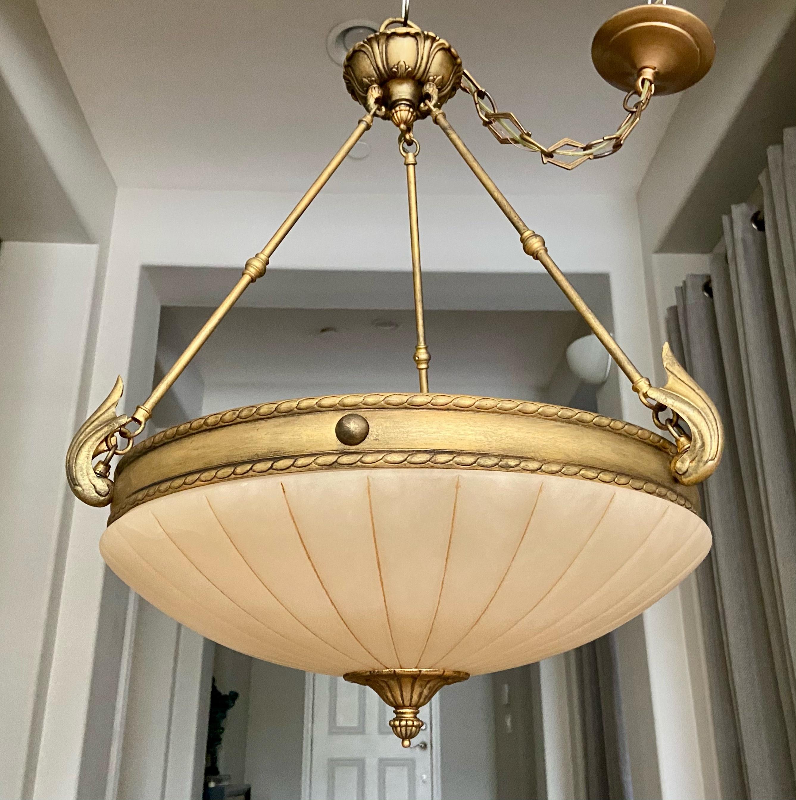 Larger scale carved alabaster chandelier with 3-light and antiqued gold finish hardware fittings. Fixture uses three regular size bulbs size bulbs.
Measures: Overall diameter is 21
