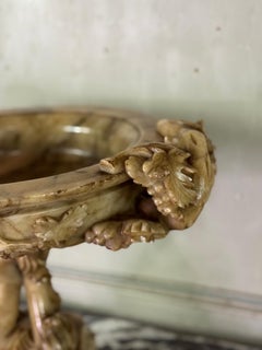 Alabaster cup decorated with vine tendrils on a base of three dolphins, circa 18