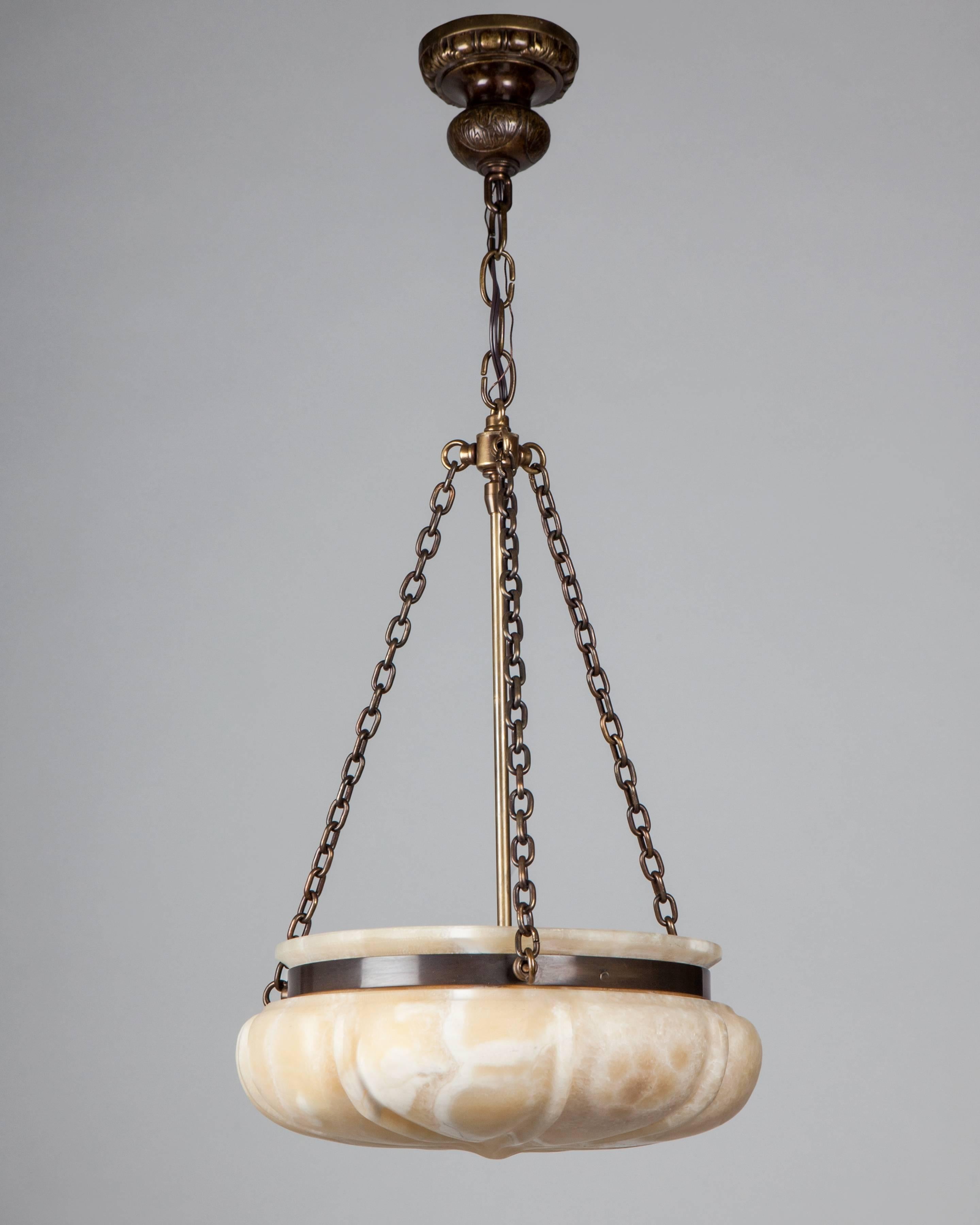 AHL4113
An inverted dome chandelier in very thick, carved alabaster with a ribbed design suspended from darkened brass hardware custom-made in our workshop. Alabaster includes natural veining, as well as the marks and scuffs of age and use inherent