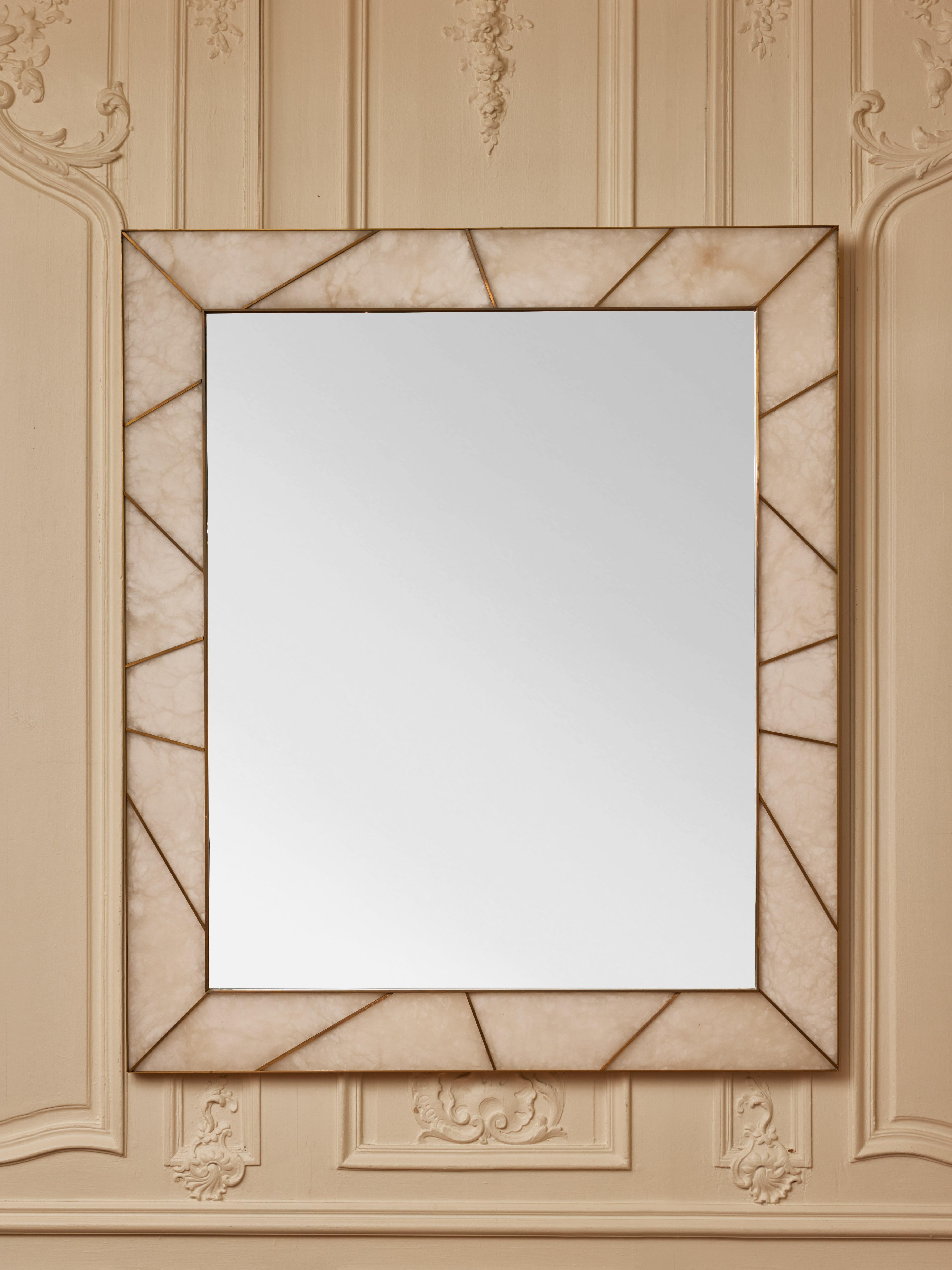 Important miroir encadré d'incrustations d'albâtre et de laiton.
Création par le Studio Glustin.