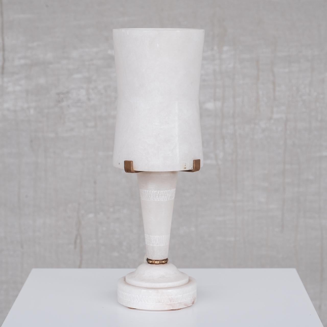 An alabaster table lamp.

France, c1950s.

Sourced in a cluster of seven varied style alabaster lamps.

Price is for the single lamp.

Some scuffs and wear commensurate with age but generally good condition.

Since re-wired and PAT