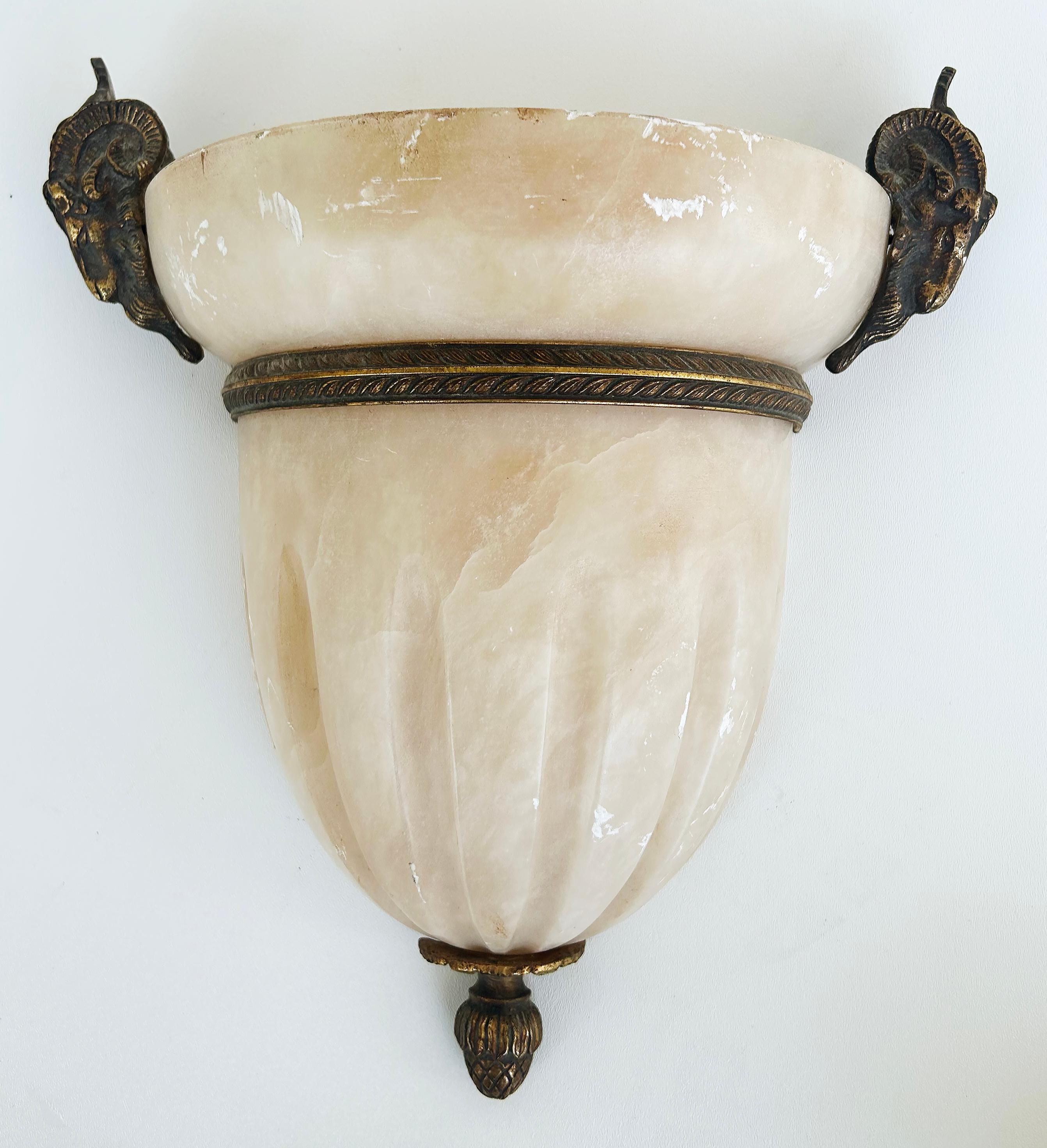 Alabaster Gilt Bronze Ram's Head Wall Sconces by Mariner, S.A., Spain, Pair

Offered for sale is a pair of alabaster and gilt bronze wall sconces made in Spain by Mariner, S.A.  This wonderful neoclassical pair of wall mounted sconces are