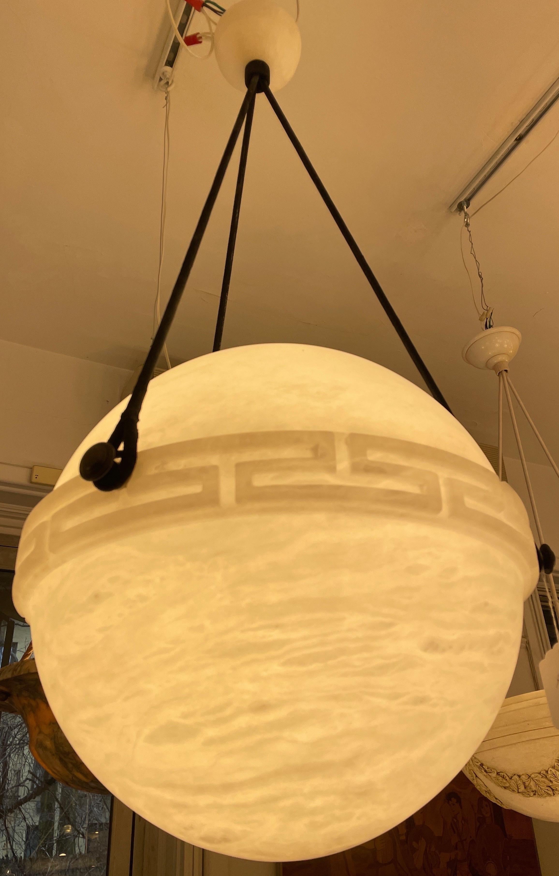 Carved from a single block of alabaster stone, adorned with a Greek key band. Features a matching canopy, and currently mounts one 75W max LED bulb. Rewiring to your specificied drop is included in the purchase price.