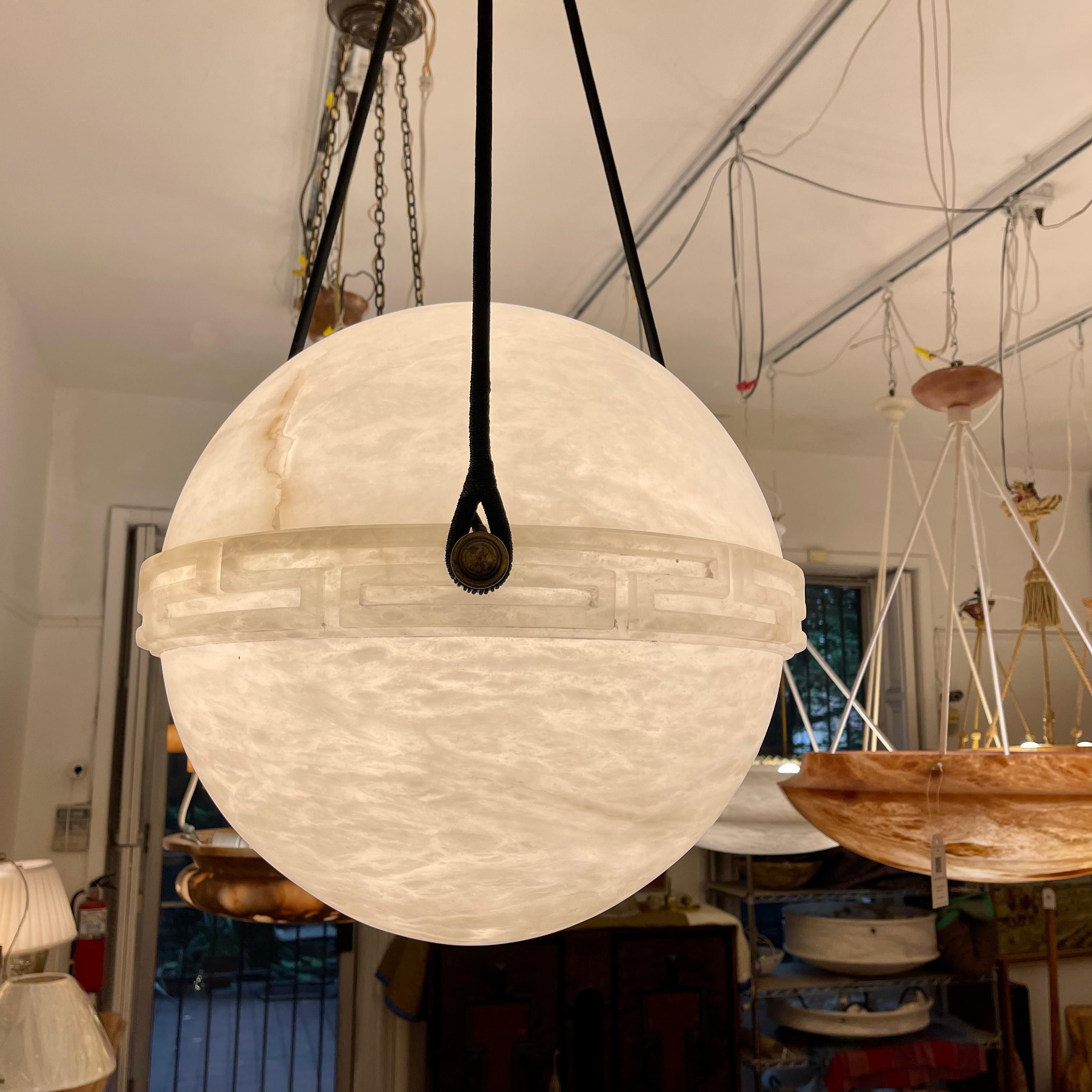Carved from a single block of alabaster stone, adorned with a Greek key band. Features a matching canopy, and currently mounts one 75W max LED bulb. Rewiring to your specificied drop is included in the purchase price.