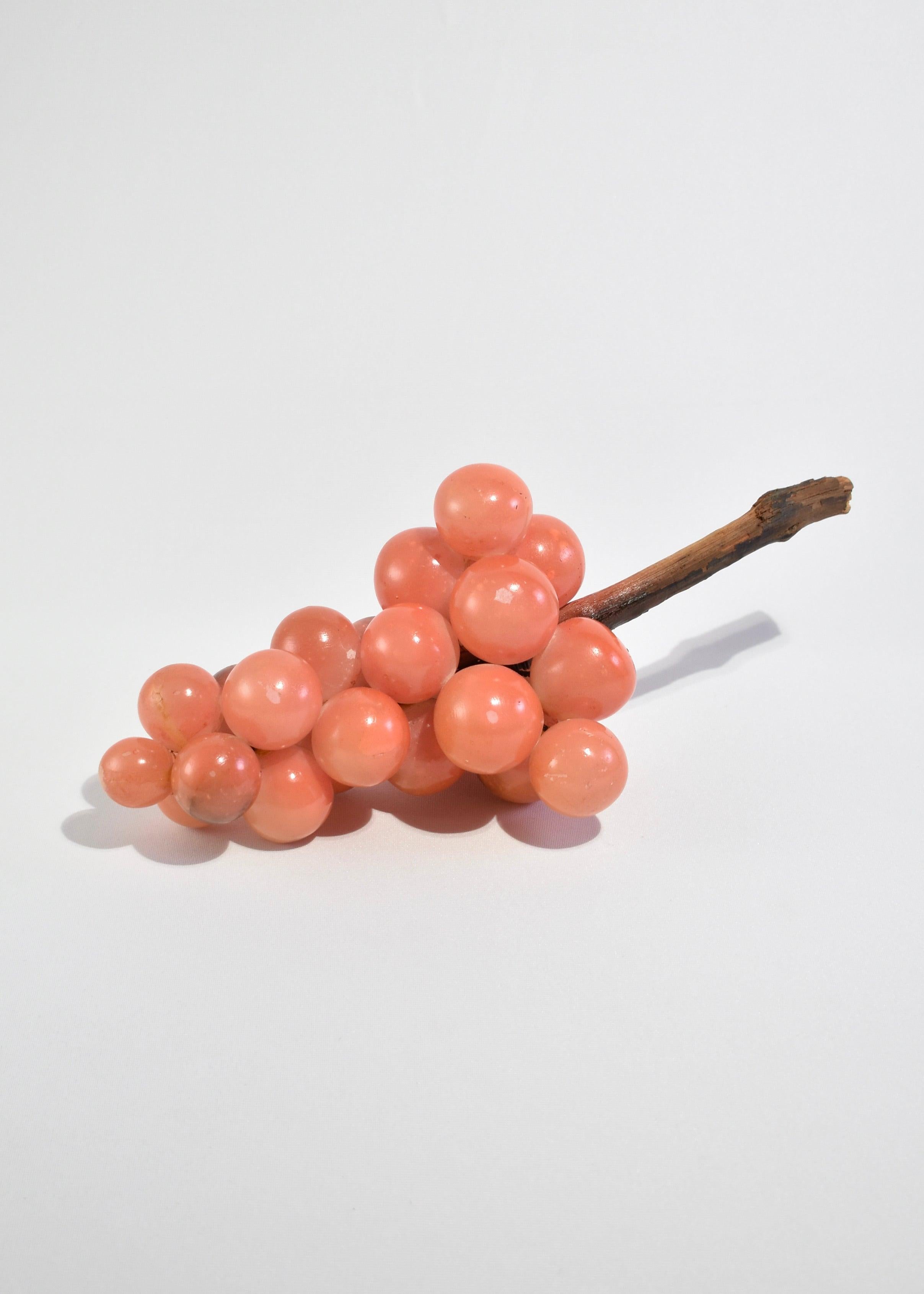 Rare, coral alabaster grape sculpture with wooden stem; a beautiful coffee table accent piece.
