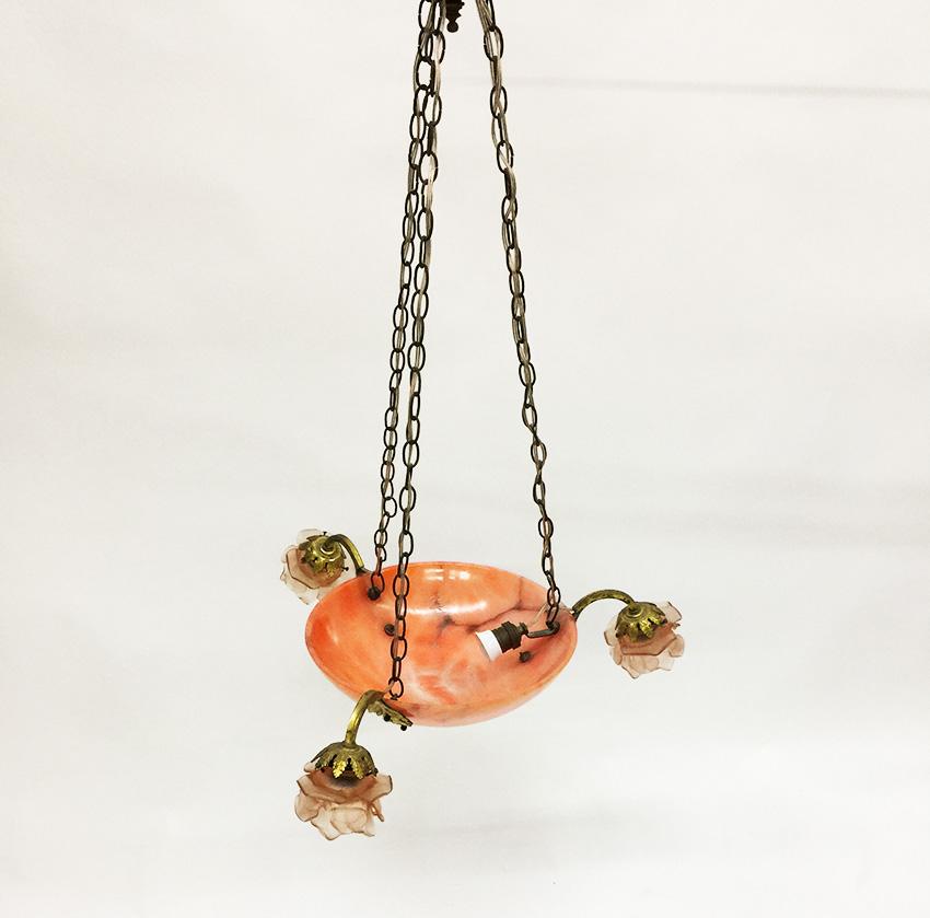Hängelampe aus Alabaster mit feuervergoldeten Ornamenten, um 1910-1920

Eine Hängelampe mit einer Alabasterschale in rosafarbener Farbe 
In der Alabasterschale der Lampe befindet sich ein Porzellanbeschlag und auf der Schale sind 3 bewaffnete