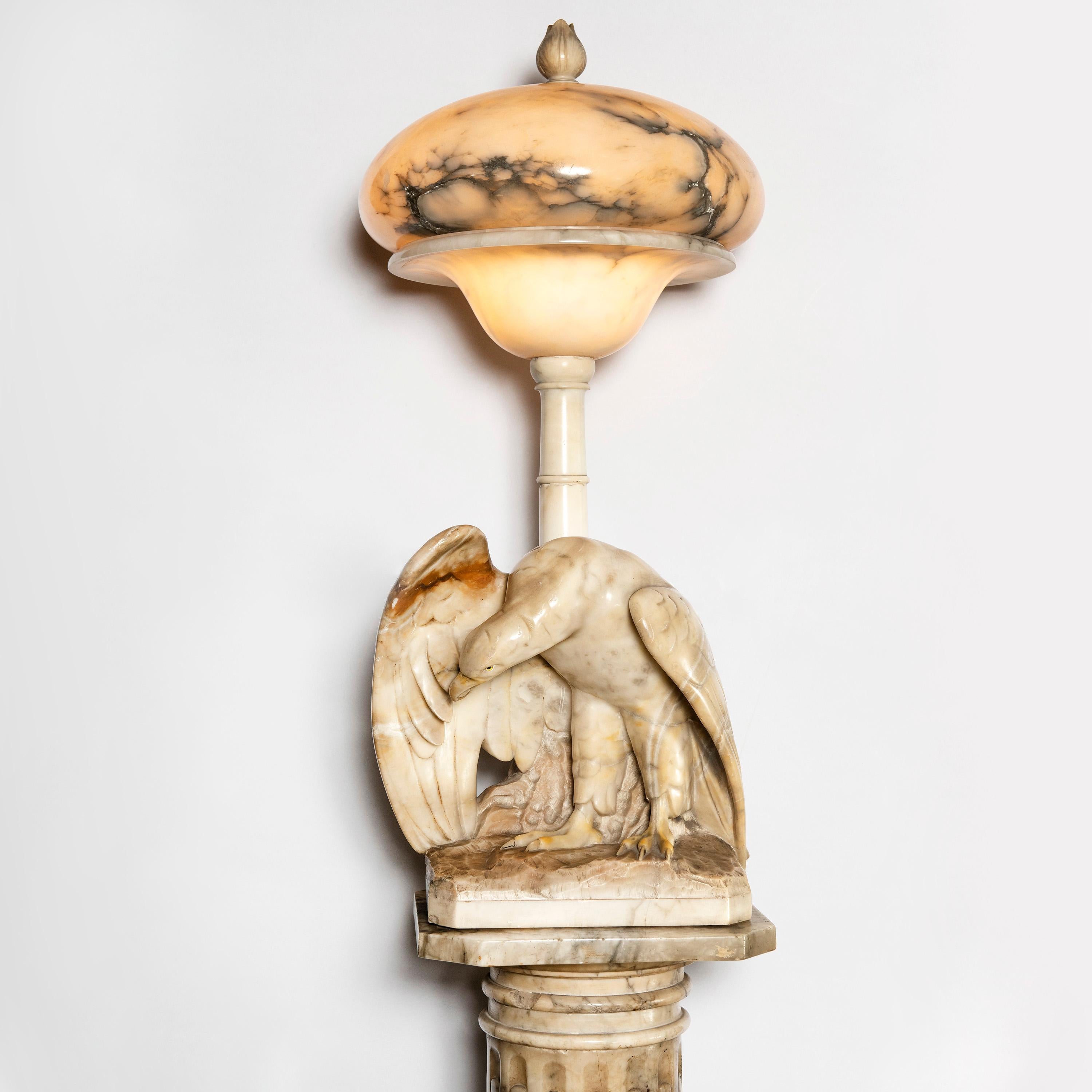 Alabaster lamp with eagle and base. Art Deco period. Italy, early 20th century.

Alabaster sculpture dimensions: 40 cm depth x 35 cm width x 84 cm height.
Alabaster pedestal dimensions: 35 cm diameter x 108 cm height.