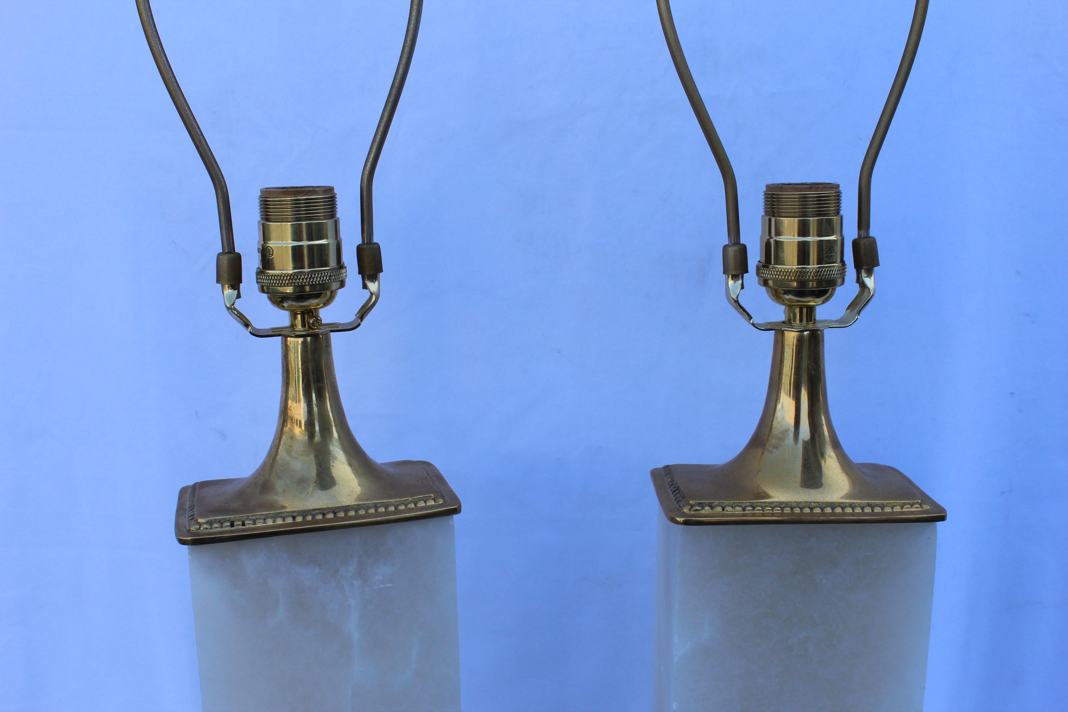 A pair of deco / modern looking lamps. Made from solid blocks of Alabaster from Spain. Designed by a LA Lighting Designer . Custom made for his showroom  this is the last pair left ,never to be made again . Metal is solid hi-polished brass. Single