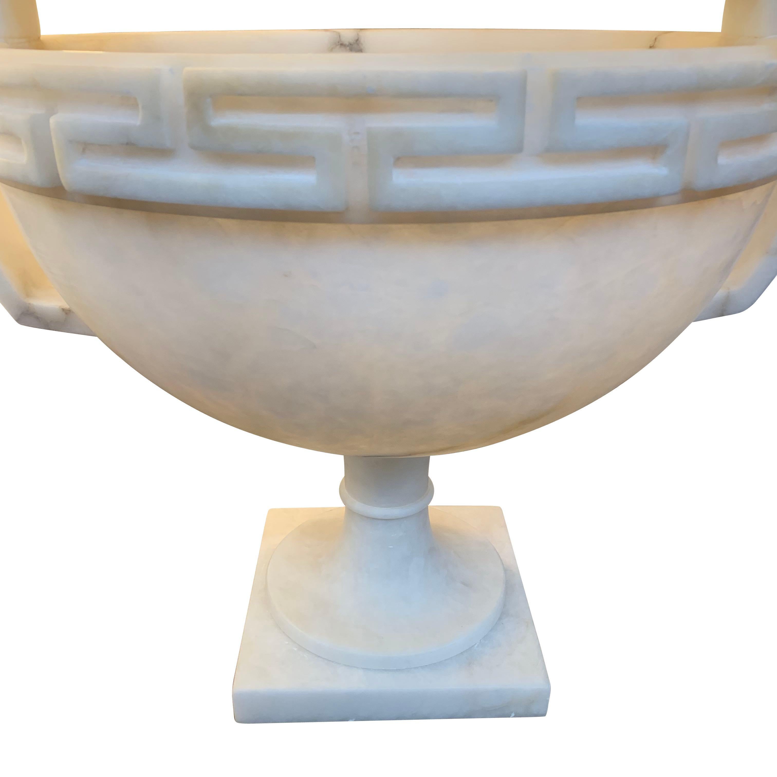 Large footed alabaster bowl with handles and Greek key decorative motif.
Measure: Base 8