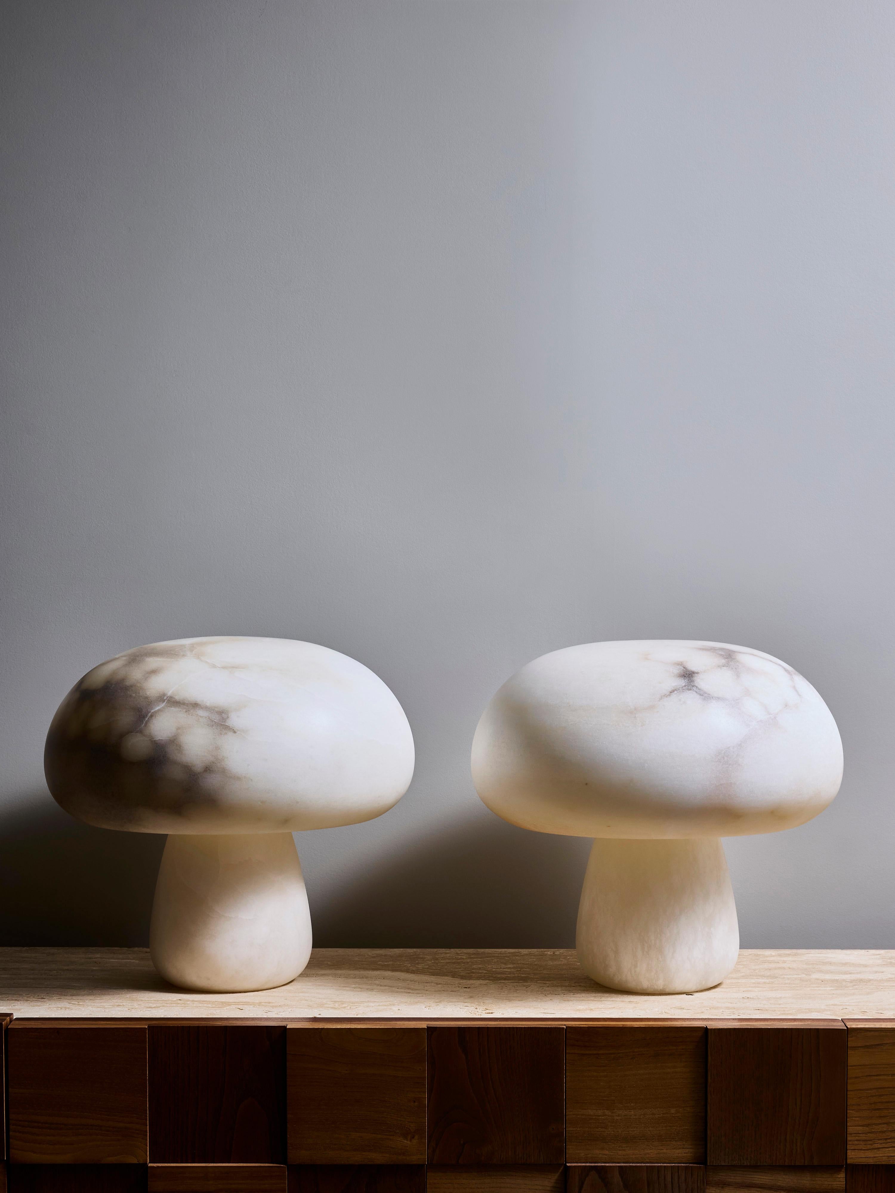 Paire de lampes de table, grandes mais courtes, composées d'une base et d'un abat-jour en albâtre, en forme de champignons. Une source de lumière par lampe, située dans le pied, donnant un éclairage dégradé de bas en haut.

Chaque lampe étant