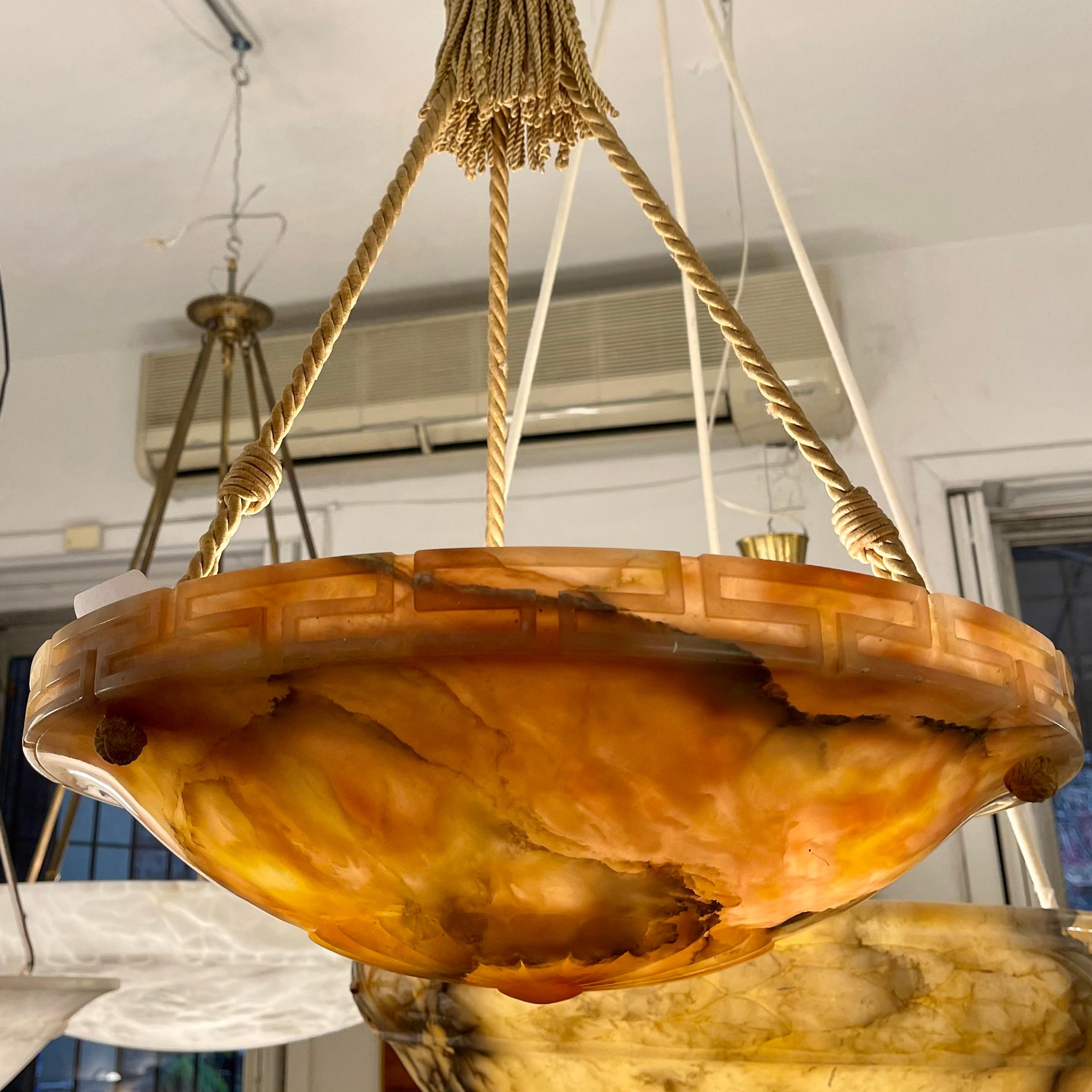 An early example of residential lighting designed specifically for electric light; earlier electric lights substituted bulbs in gas candlebras. A beautifully carved greek key surrounds the bowl, which is suspended on the original ropes and canopy.