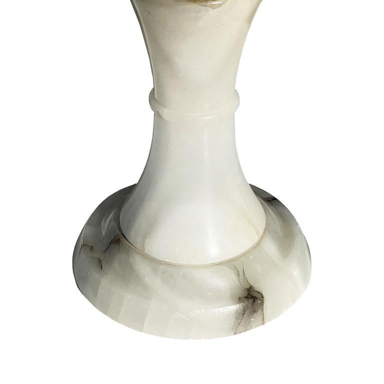 A beautiful stone cachepot or decorative fruit bowl of alabaster. Scalloped rounded edges decorate the sides, and a wonderful veining shows throughout. 

The bowl sits upon a fluted pedestal, with a round circular base. 

This piece would be