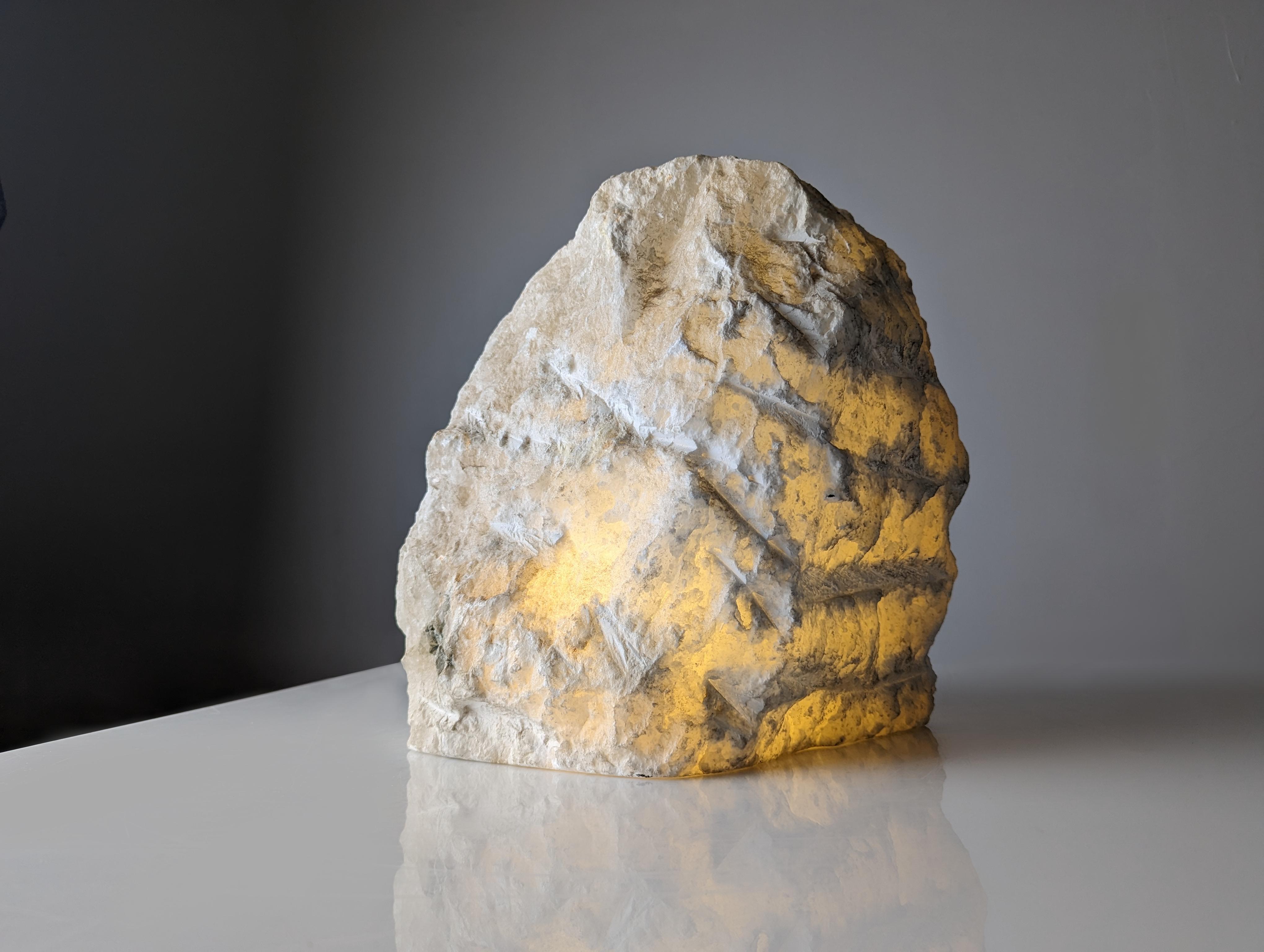 Discover the organic beauty of this Natural Alabaster lamp. A functional decorative object with the visual force of its textures that presents the alabaster rock in all its splendor. The soft light that emanates from its interior creates a warm and