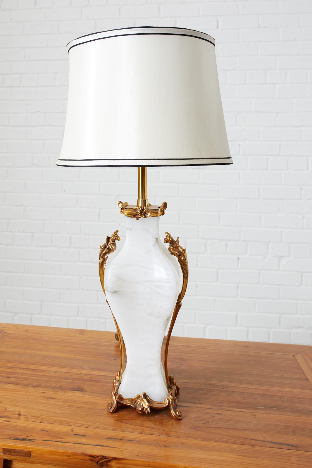 Stunning Alabaster table lamp by Marbro Lamp Company featuring a brass base tinted in rose gold with climbing acanthus and matching top. This special order lamp weighs over twenty pounds with hardware and finial. The lamp has been stamped and