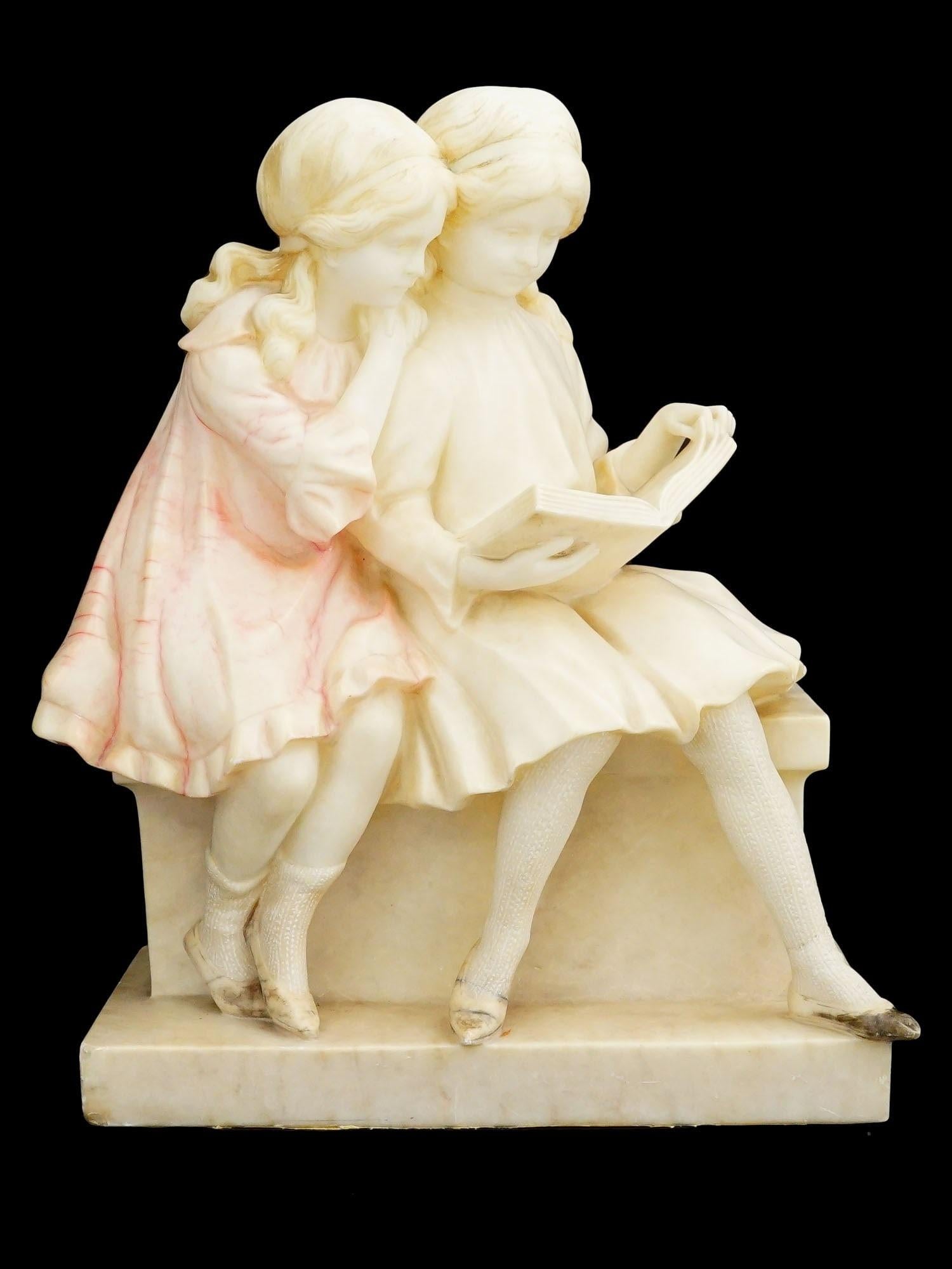 Scultura in alabastro finemente scolpita di due ragazze sedute che leggono un libro, alla maniera del maestro italiano Umberto Stiaccini, attivo alla fine del XIX secolo.  Misura 14 x 11 1/4 x 6 1/4 pollici e sembra non essere firmato.