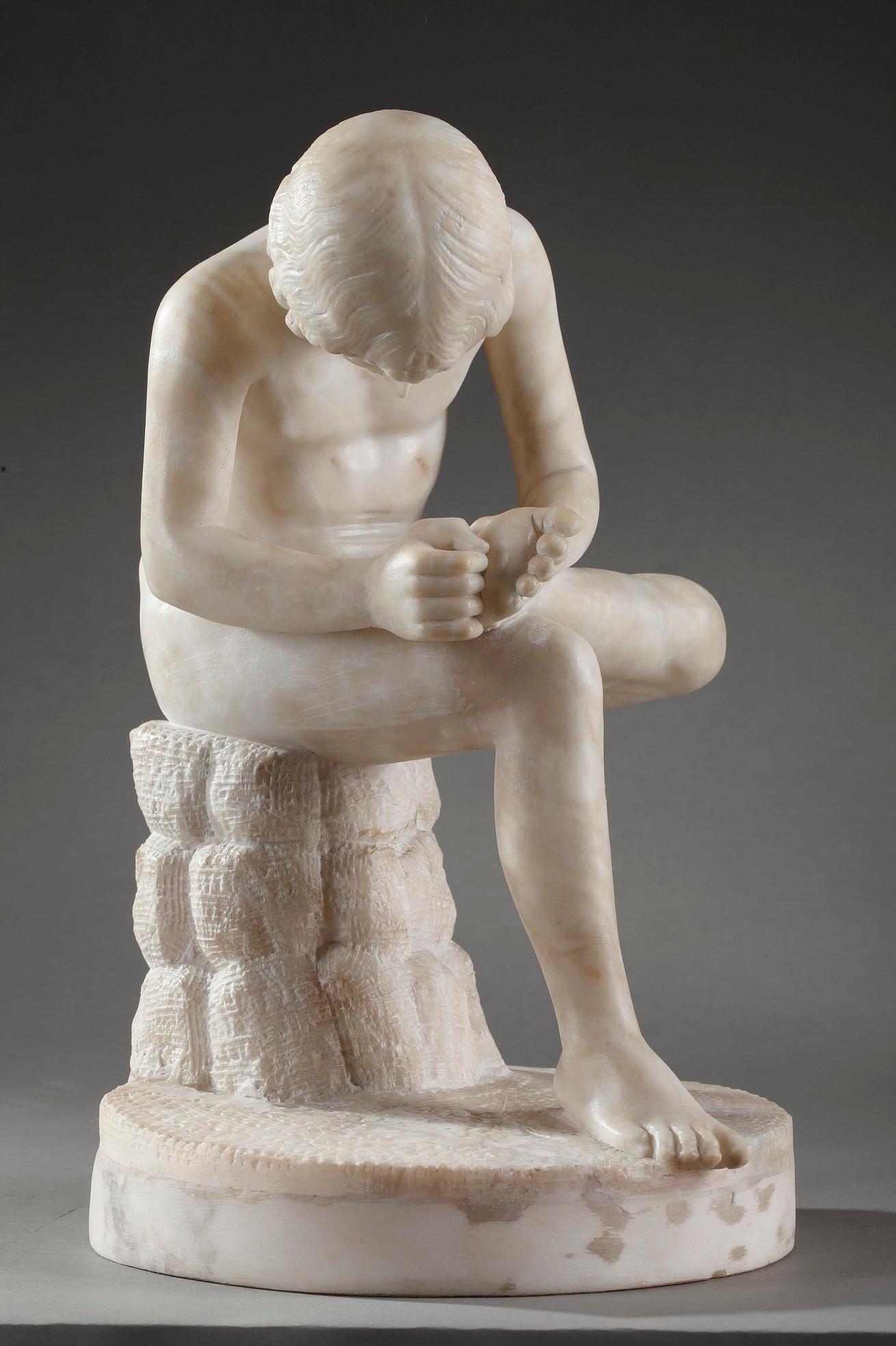Alabaster statuette after the Hellenistic sculpture Spinario. Il features a boy pulling a thorn from the bottom of his foot as he sits cross legged on a boulder. One of the antique models is now housed in the Palazzo dei Conservatori, in