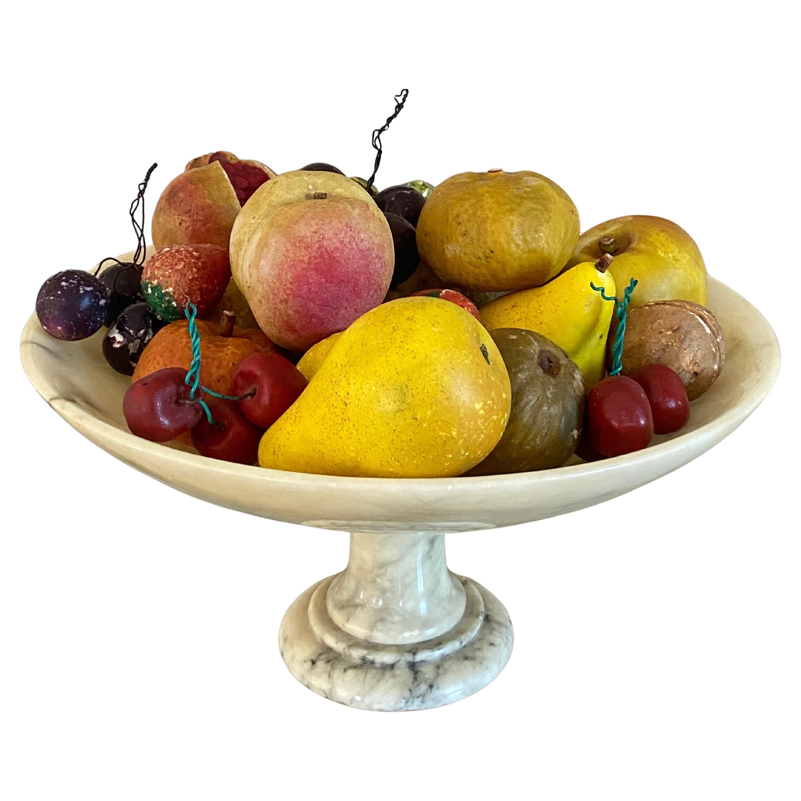 Gran surtido de frutas italianas de mármol y alabastro, talladas y pintadas a mano, dispuestas en una tazza redonda de mármol blanco con base de pedestal. Un total de 24 piezas de fruta en buen estado original general, con pequeños arañazos,