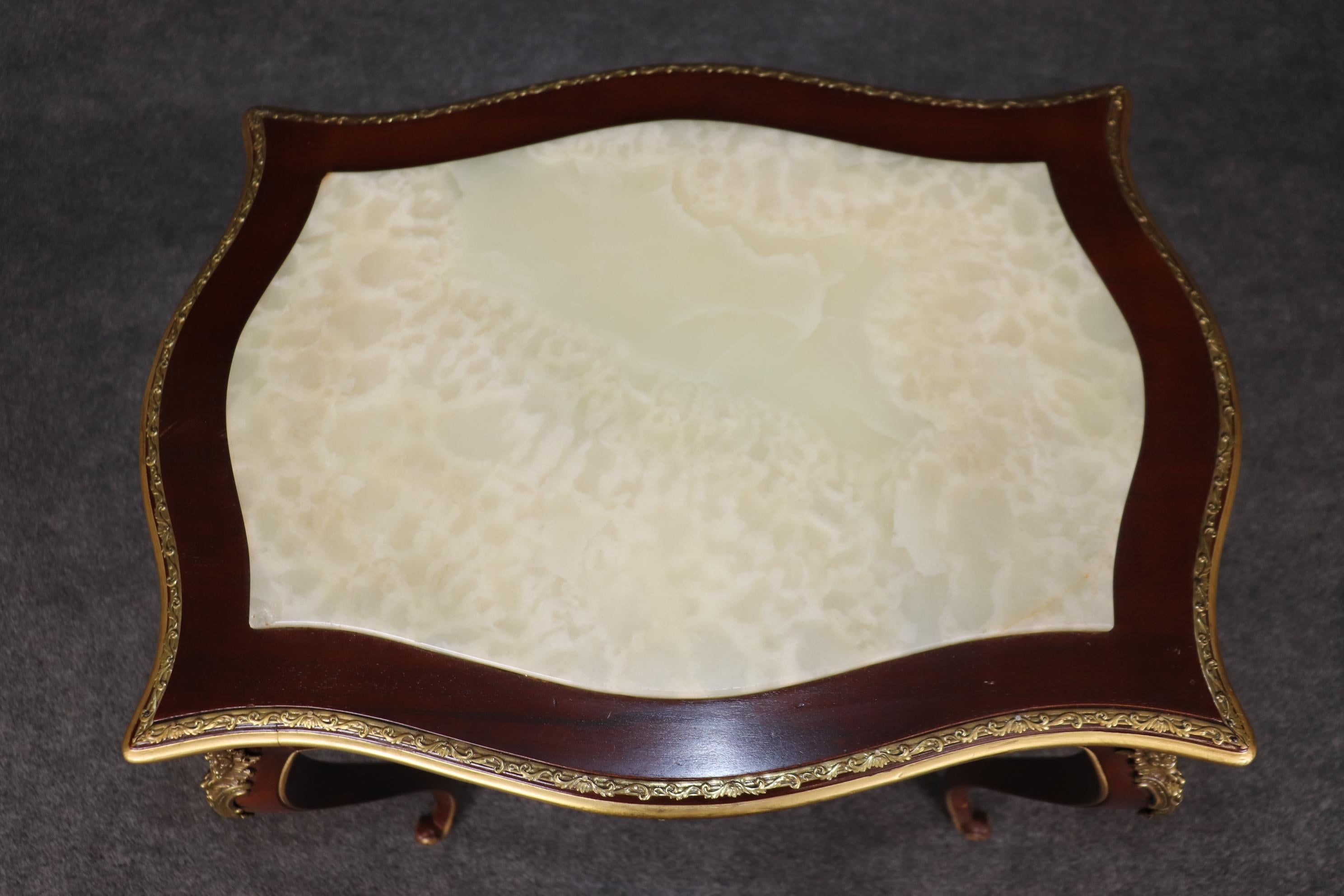 This is a beautiful alabster top gilded and bronze mounted center table with a gorgeous mahogany frame. The table is in good condition with no significant issues or damage. The table dates to the 1950s and is French-made. Dimension: 29.25 inches