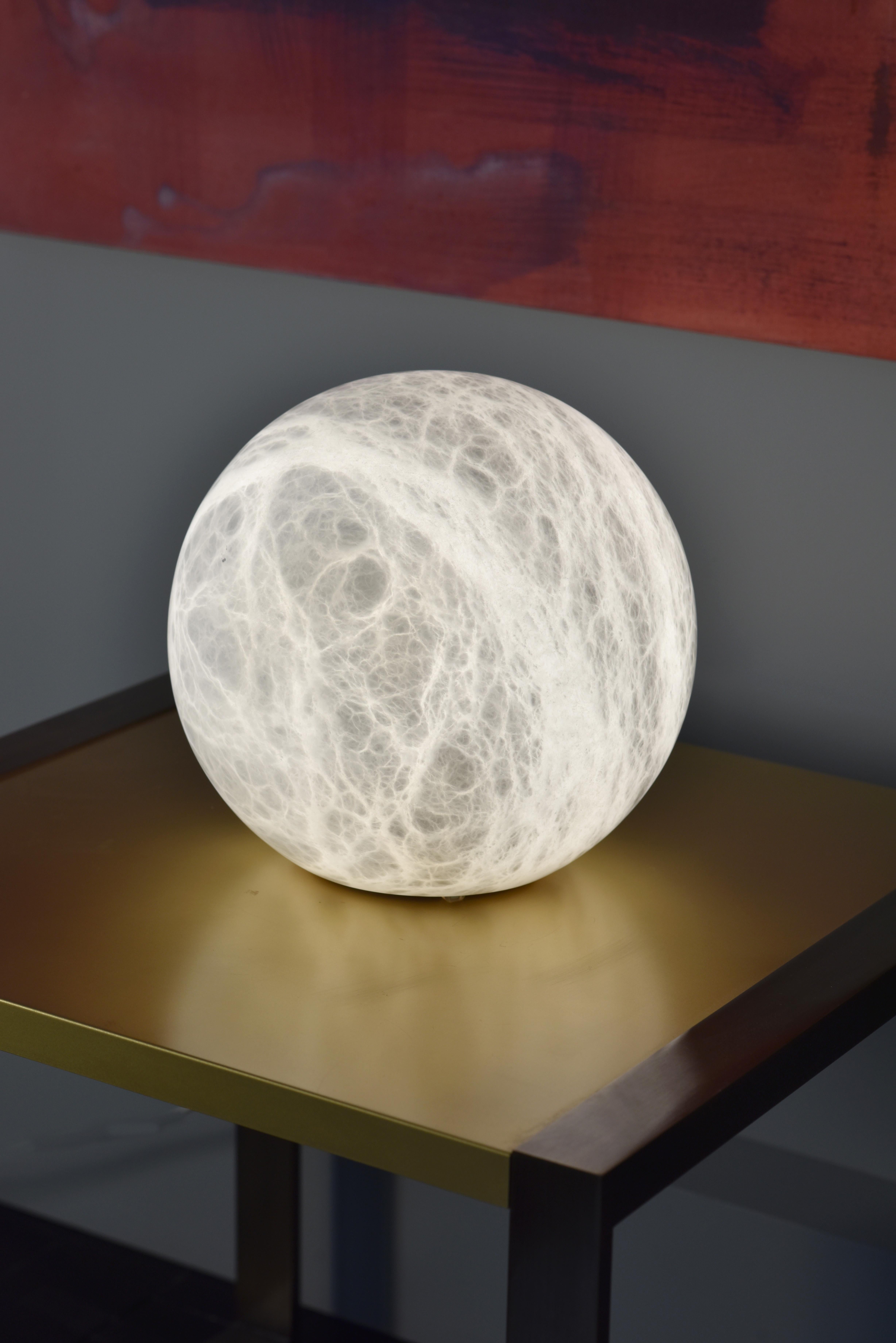 Alabaster Galet Uno Table Light by Atelier Alain Ellouz
Collection Atelier 
Atelier Alain Ellouz
Dimensions: Ø 19.7’’
Materials: Alabaster
Weight: 75 lb

Grey textile cable l. 78,7’’ 
Bulb LED E26 3000K - 15,5W - no dimmable - 20 000 hours
640 to