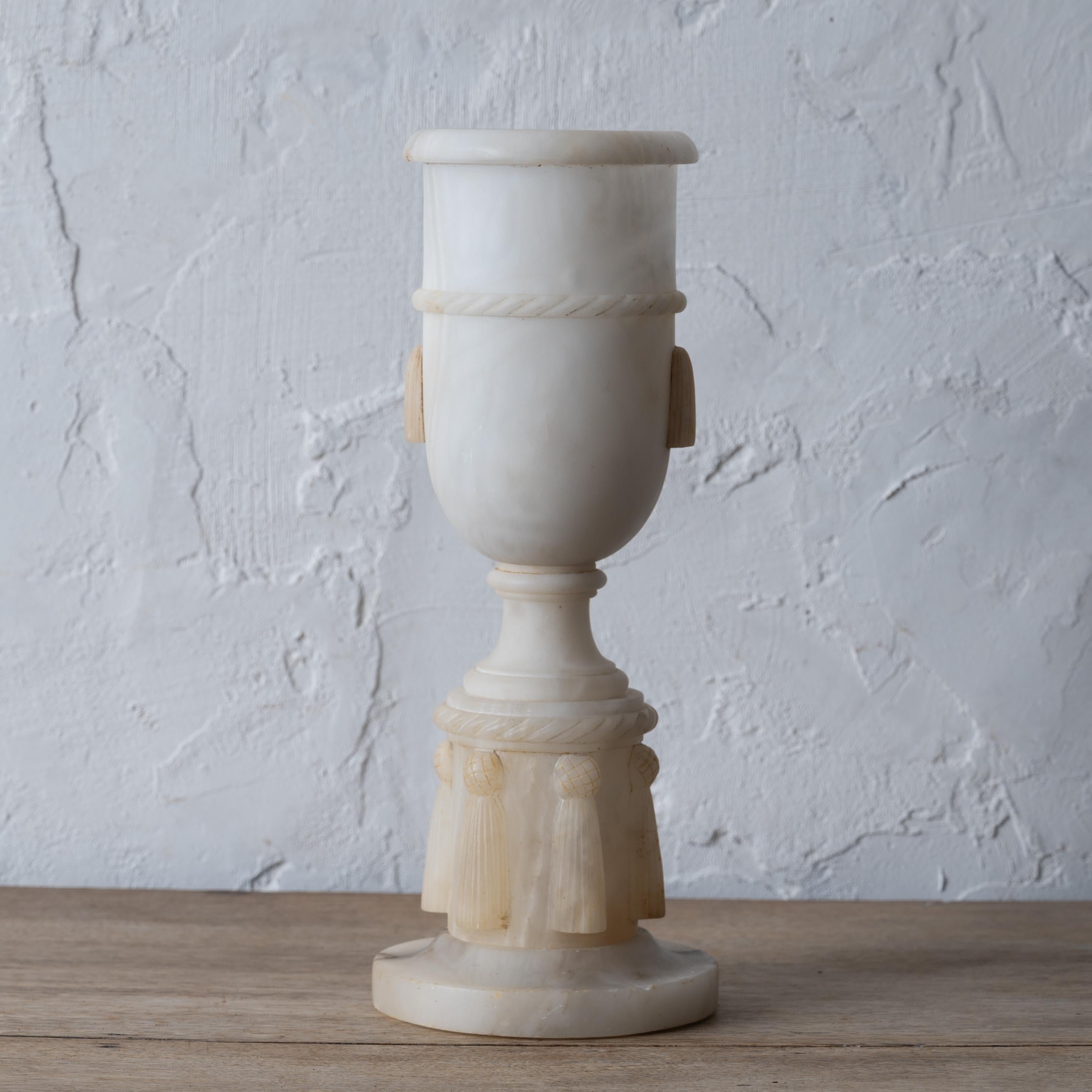 A neoclassical alabaster urn lamp, France, early 20th century.

5 ½ inches wide by 4 ½ inches deep by 10 ½ inches to top of alabaster;  22 ¼ inches tall to top of finial

