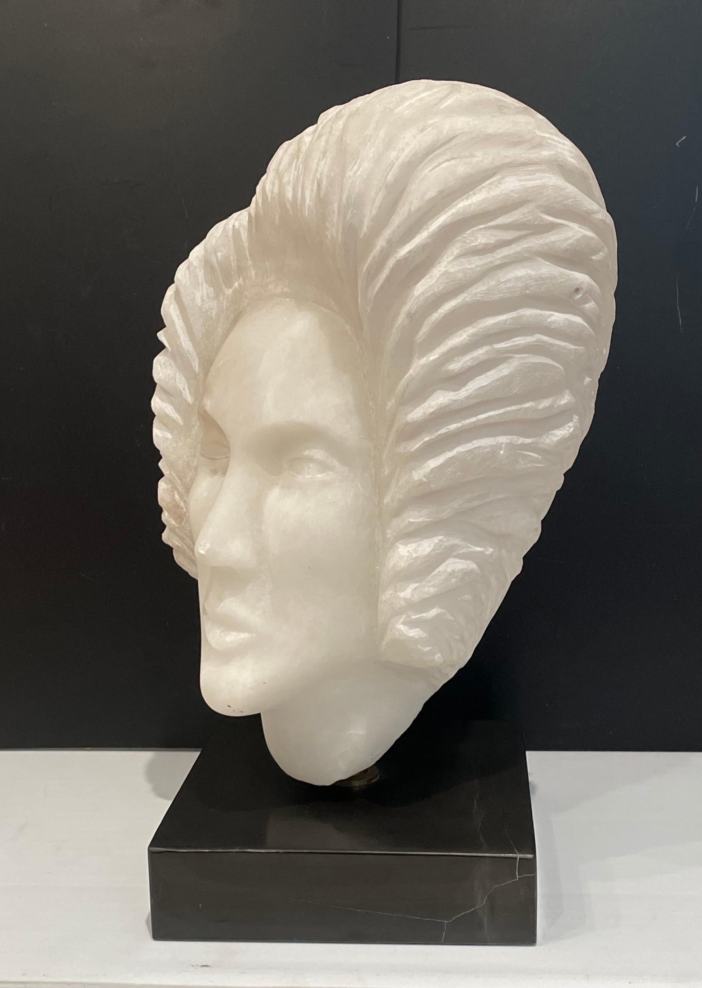 Beautiful hand-carved woman's head sculpture, sitting on a black marble base with a brass pivot that rotates its well done and beautiful circa 1980's not signed.