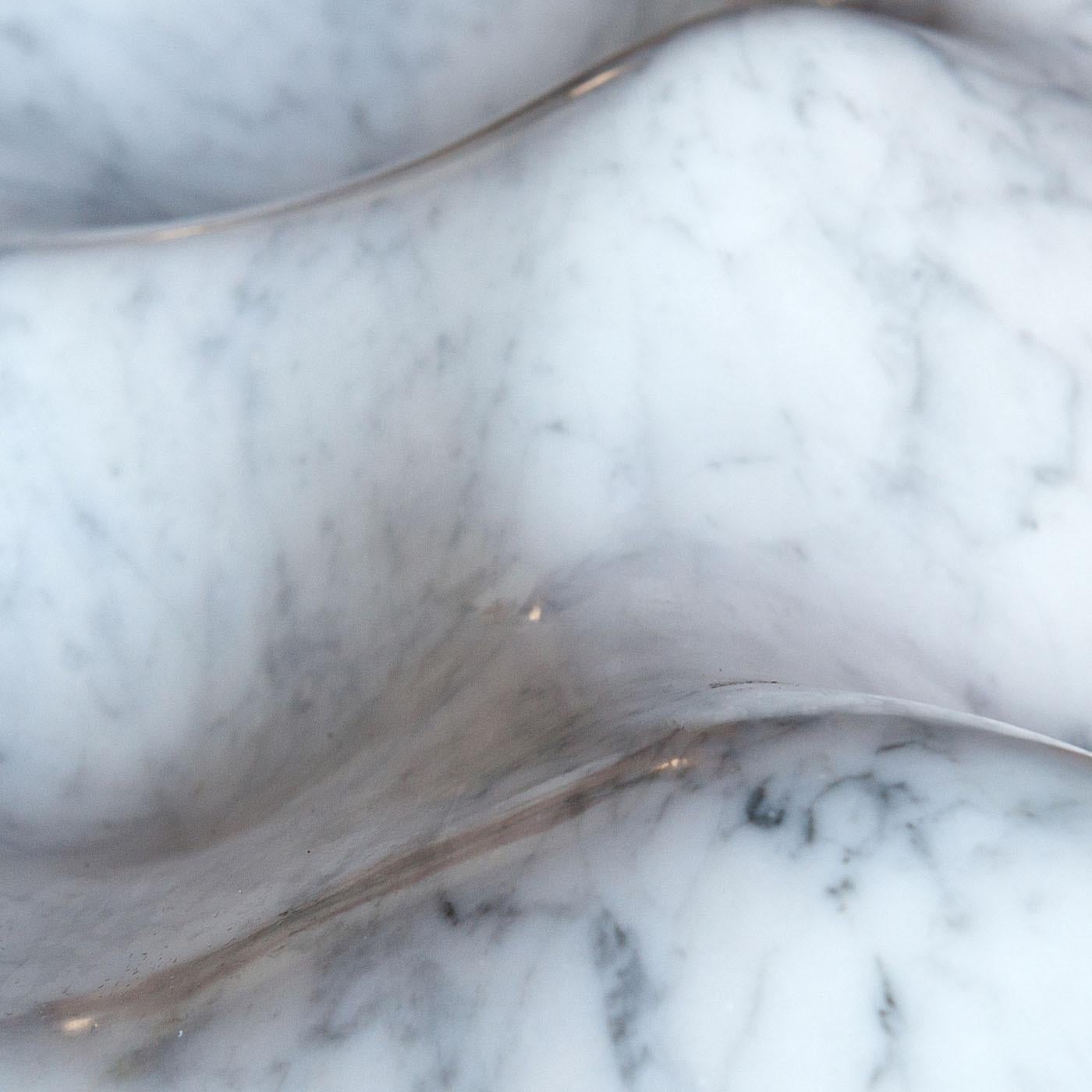 Marked by a sleek and sinuous shape that elevates the pure essence of white Carrara marble to timeless sophistication, this centerpiece will make for an elegant and refined accent to a contemporary dining table. Recalling sand dunes shaped by the