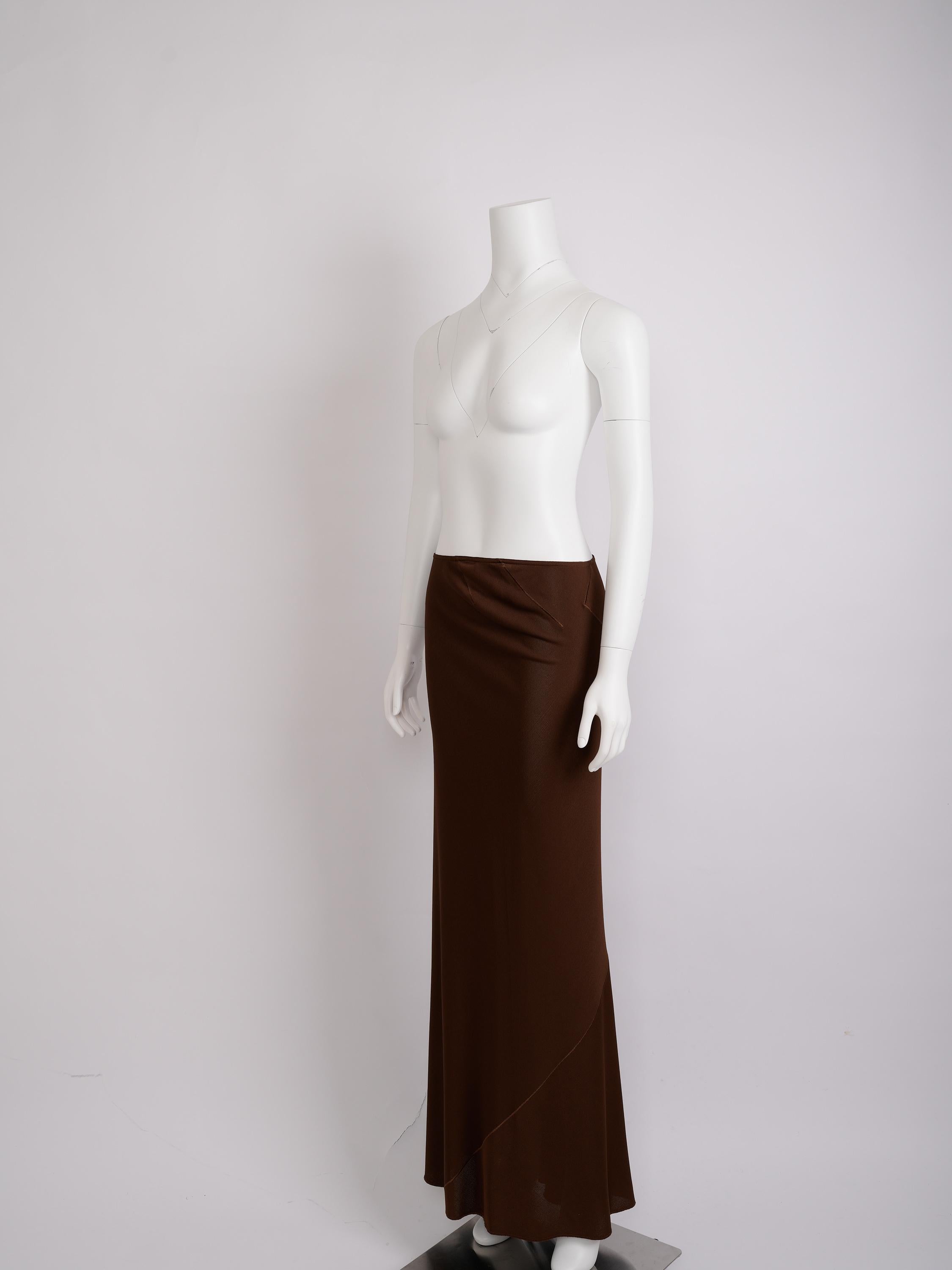 Un pezzo eccezionale dei primi lavori di Azzedine Alaïa, questa gonna in jersey marrone del 1986 mostra l'approccio scultoreo dello stilista alla silhouette e al movimento.

Realizzata in un morbido jersey elasticizzato, la gonna presenta una vita