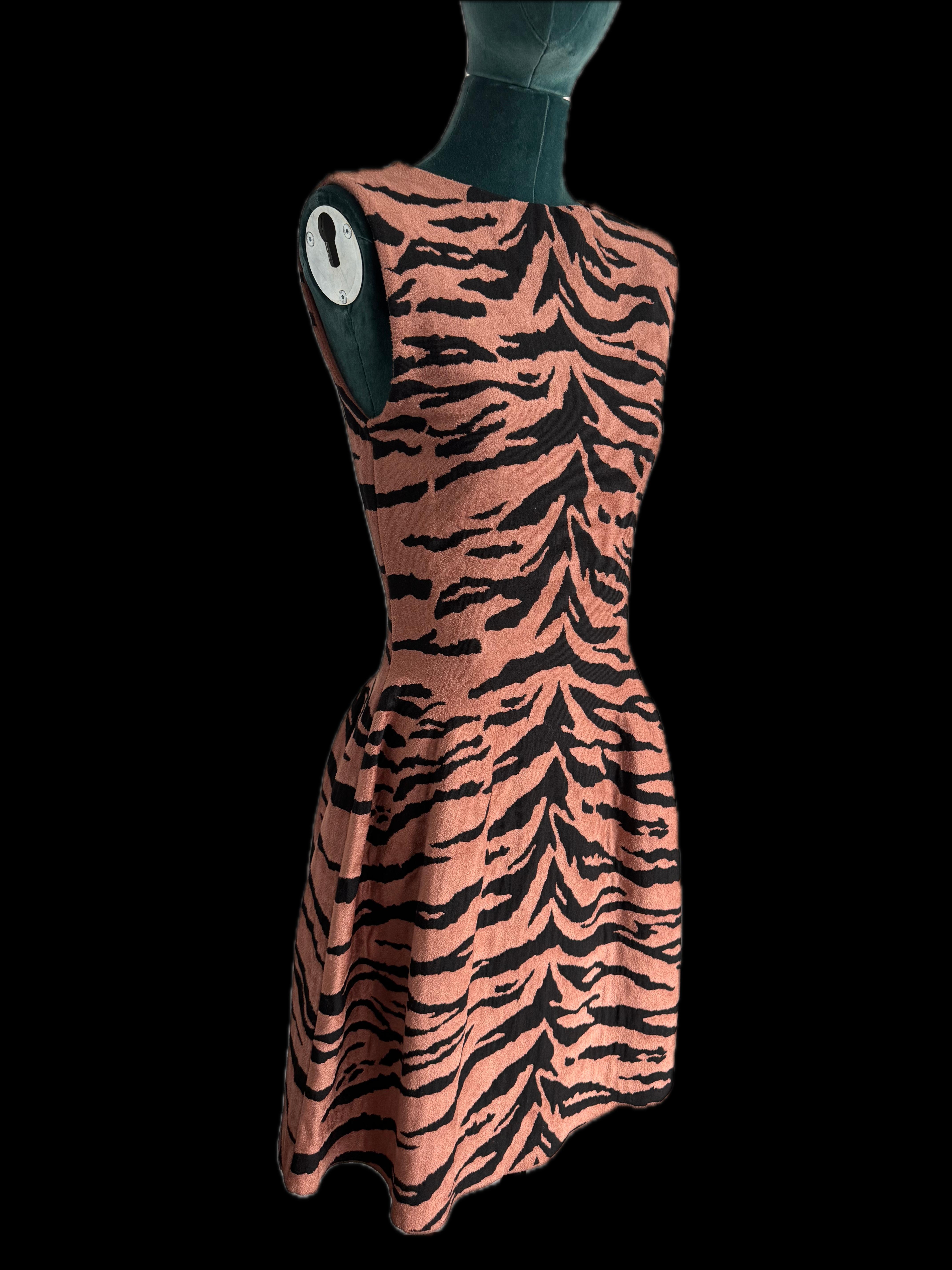 
Introducing the epitome of fierce elegance: the Alaïa Tiger Print Mini Dress. This stunning dress, in a French size 38, is brand new with tags and promises to make a bold statement with its eye-catching tiger print and impeccable