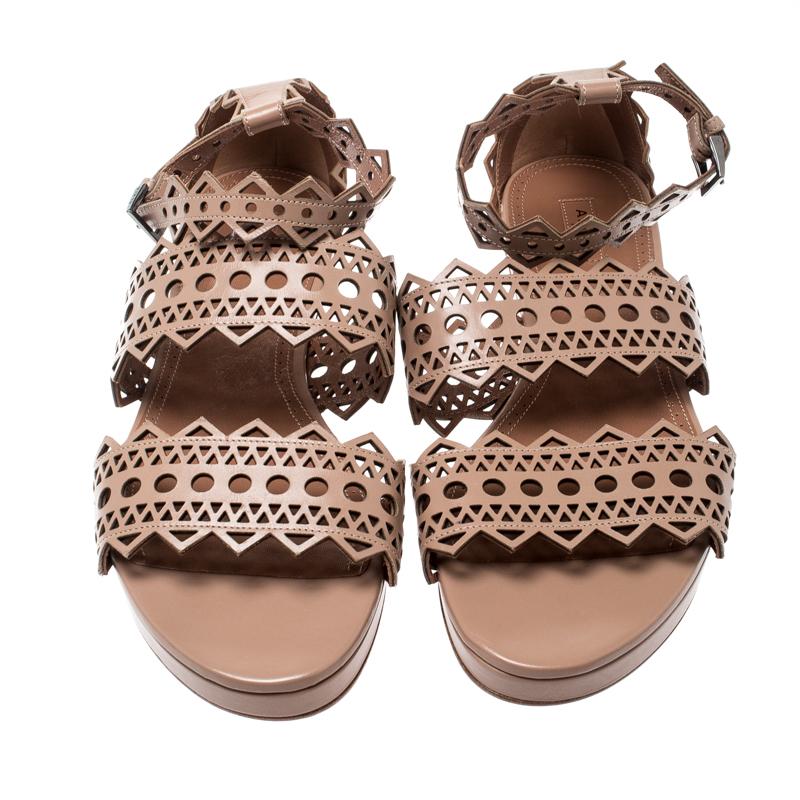 Your edgy style and wardrobe get a new addition with these fabulous flat sandals from Alaia. The beige flats are crafted from leather and feature an open toe silhouette. They flaunt a laser-cut design on the straps with buckle fastening at the