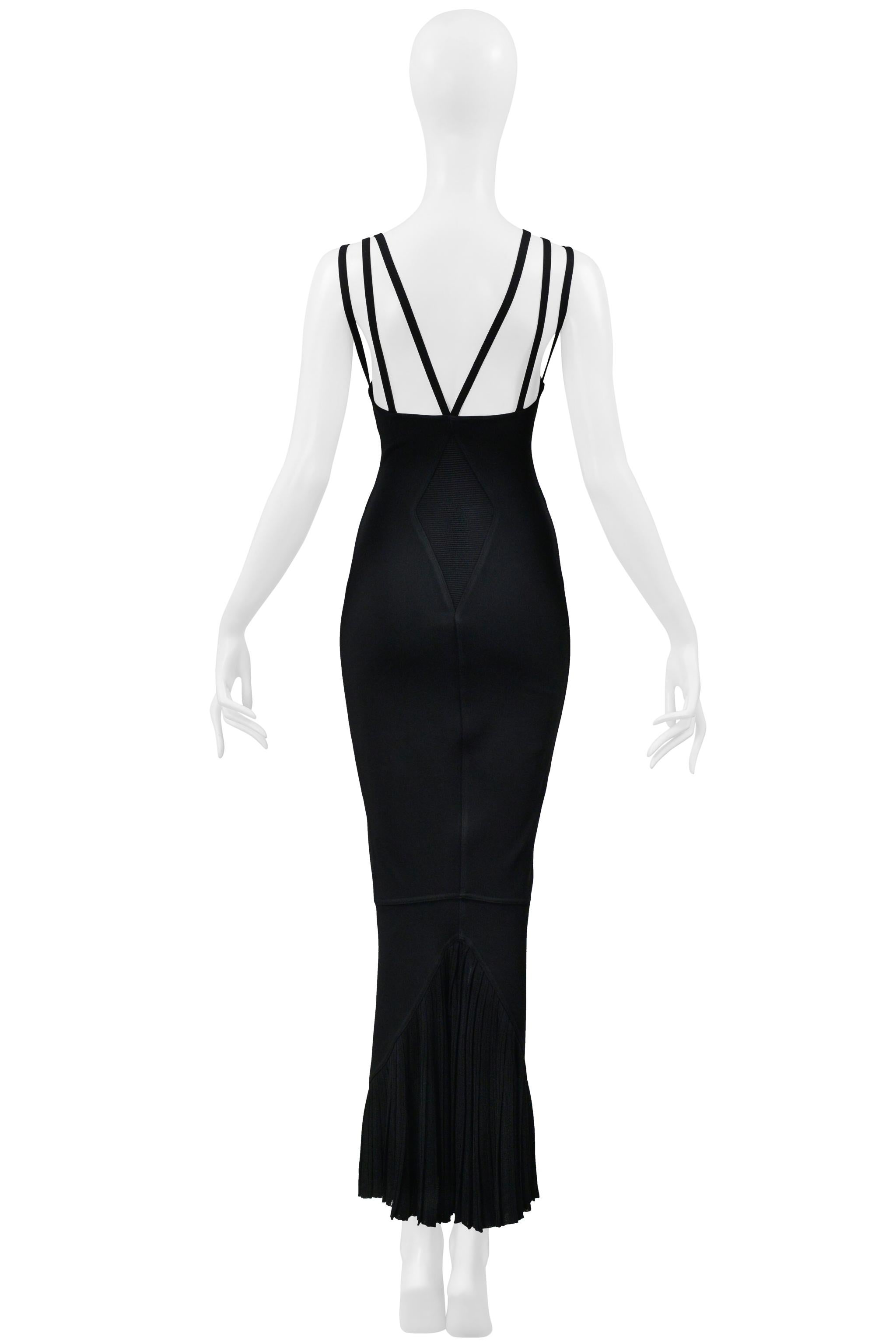 Resurrection Vintage freut sich, ein klassisches, schwarzes Abendkleid von Azzedine Alaia anbieten zu können, das sich durch einen Fischschwanzsaum aus Spitze, mehrere Bänder, einen tiefen Ausschnitt, Alaias ikonische Bodycon-Passform und