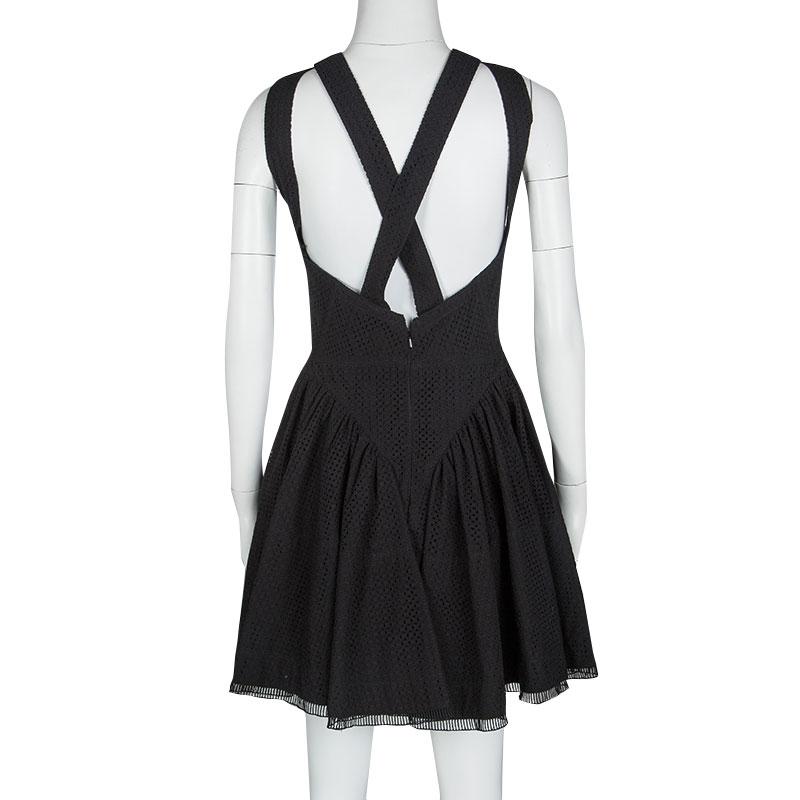 Perfect for the day parties and events, this Alaia sleeveless dress is classic, feminine and chic to dress up or even wear on its own. Constructed in black cotton fabric, this eyelet embroidered dress features a halter neckline at the front and with