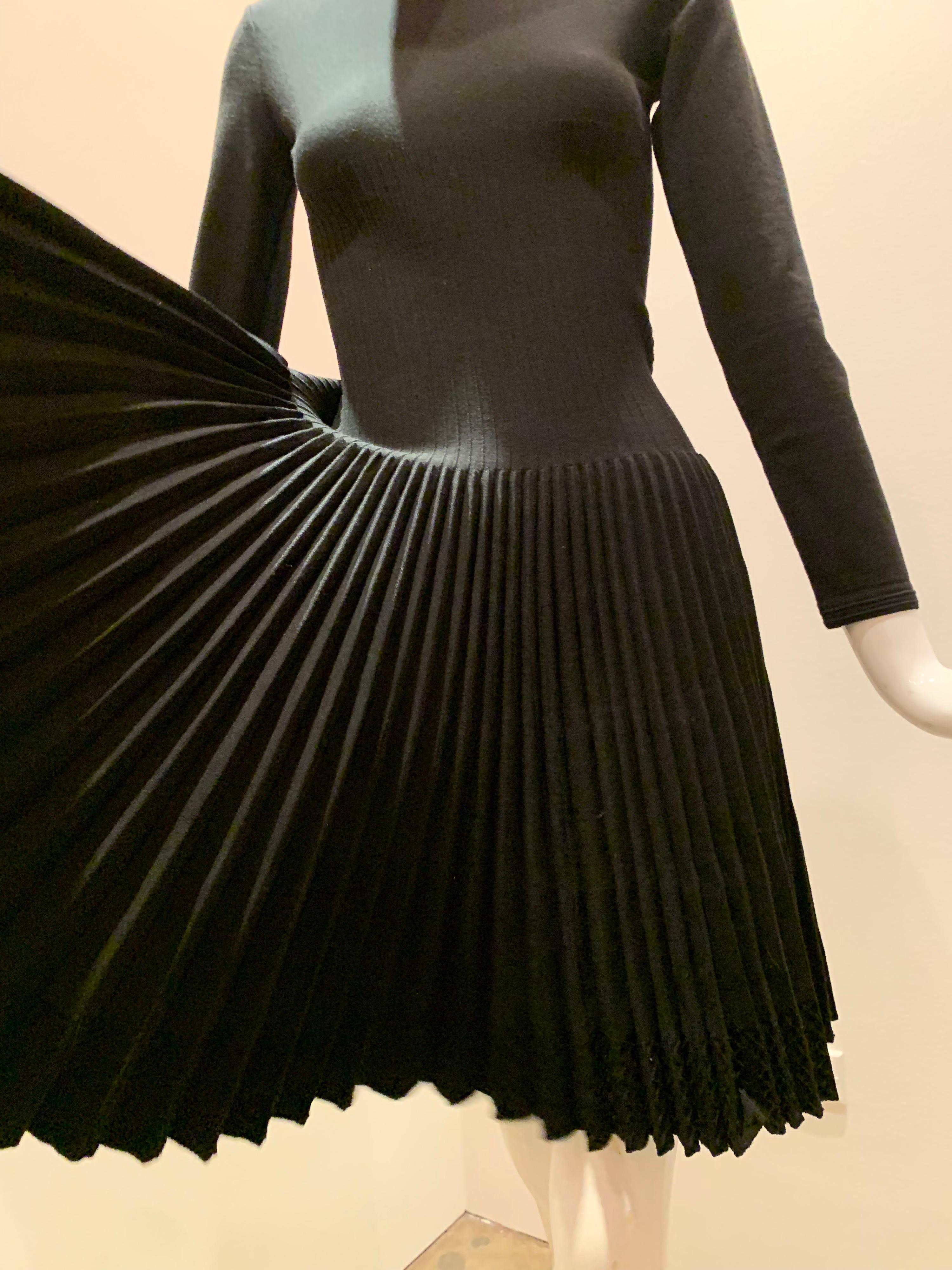 A wonderful basic from Azzedine Alaia:  A blackwool knit dress with a high crew banded neckline, 3/4 sleeves, a dropped waist and a full pleated skirt.  Zippered back. 