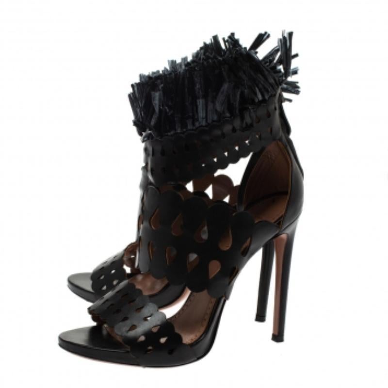 Votre style avant-gardiste et votre garde-robe s'enrichiront de ces sandales uniques signées Alaia. Ces sandales de couleur noire sont confectionnées en cuir et en paille et présentent une silhouette à bout ouvert. Ils arborent un motif découpé au
