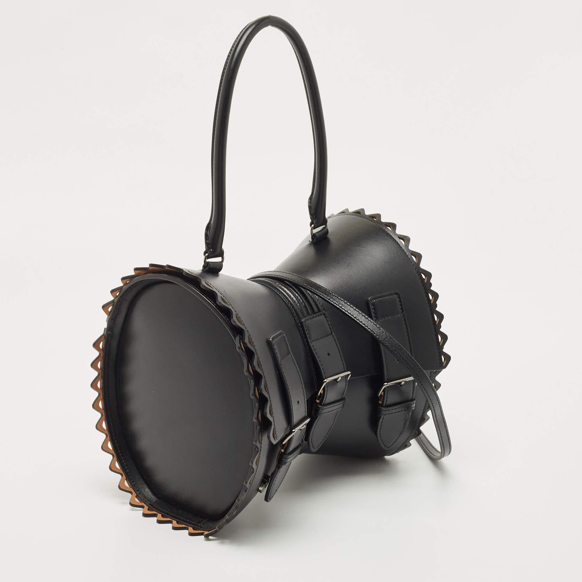 The Alaia Edition 1992 Corset bag is a timeless fashion piece. Crafted from premium black leather, it features a unique corset-inspired design with intricate stitching details. The bag exudes elegance and sophistication, making it a must-have