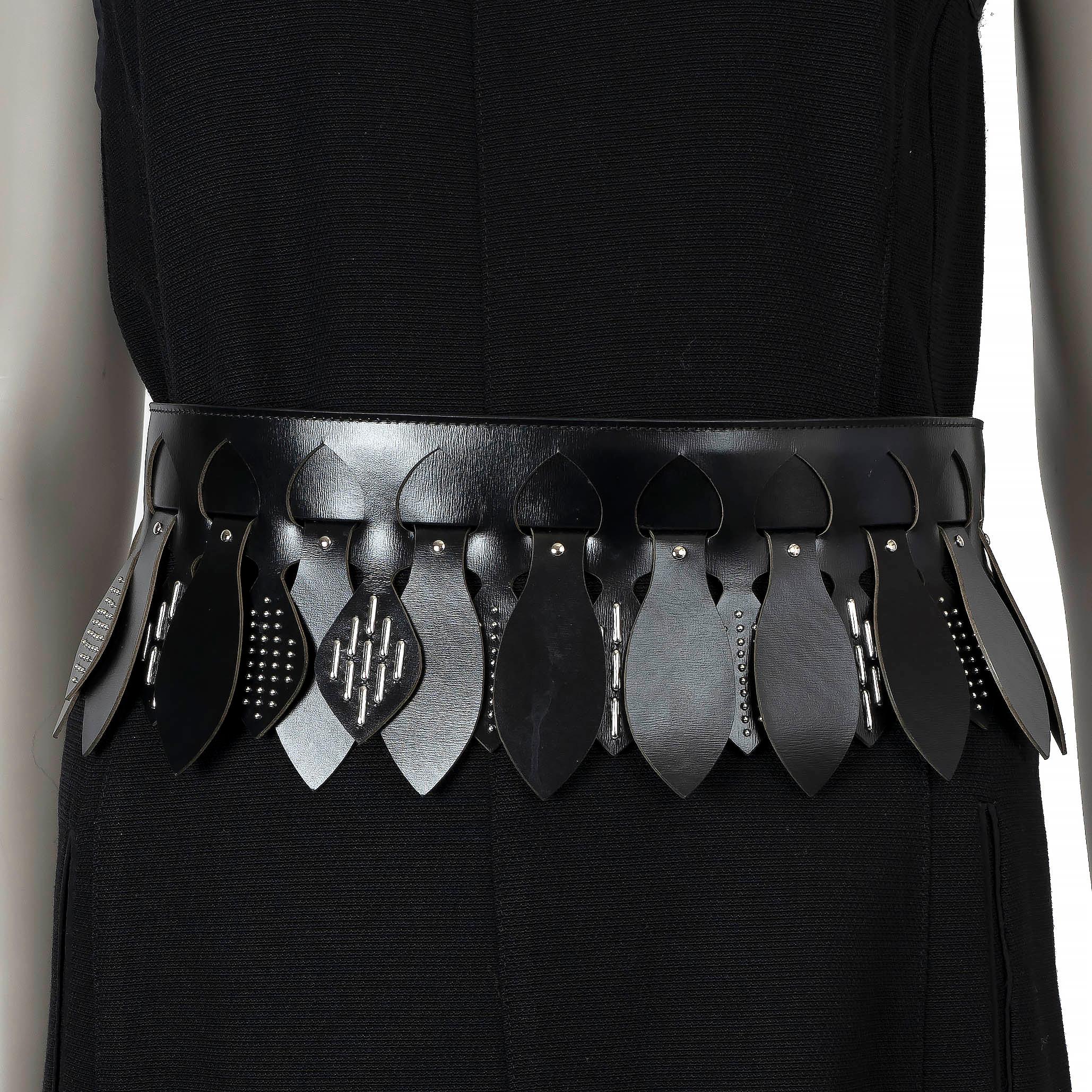 This 100% authentic Alaïa wide corset waist belt is crafted from black leather and features a striking silver-tone studded leaves design, created with intricate laser-cut detailing. This bold statement piece cinches the waist beautifully, adding a