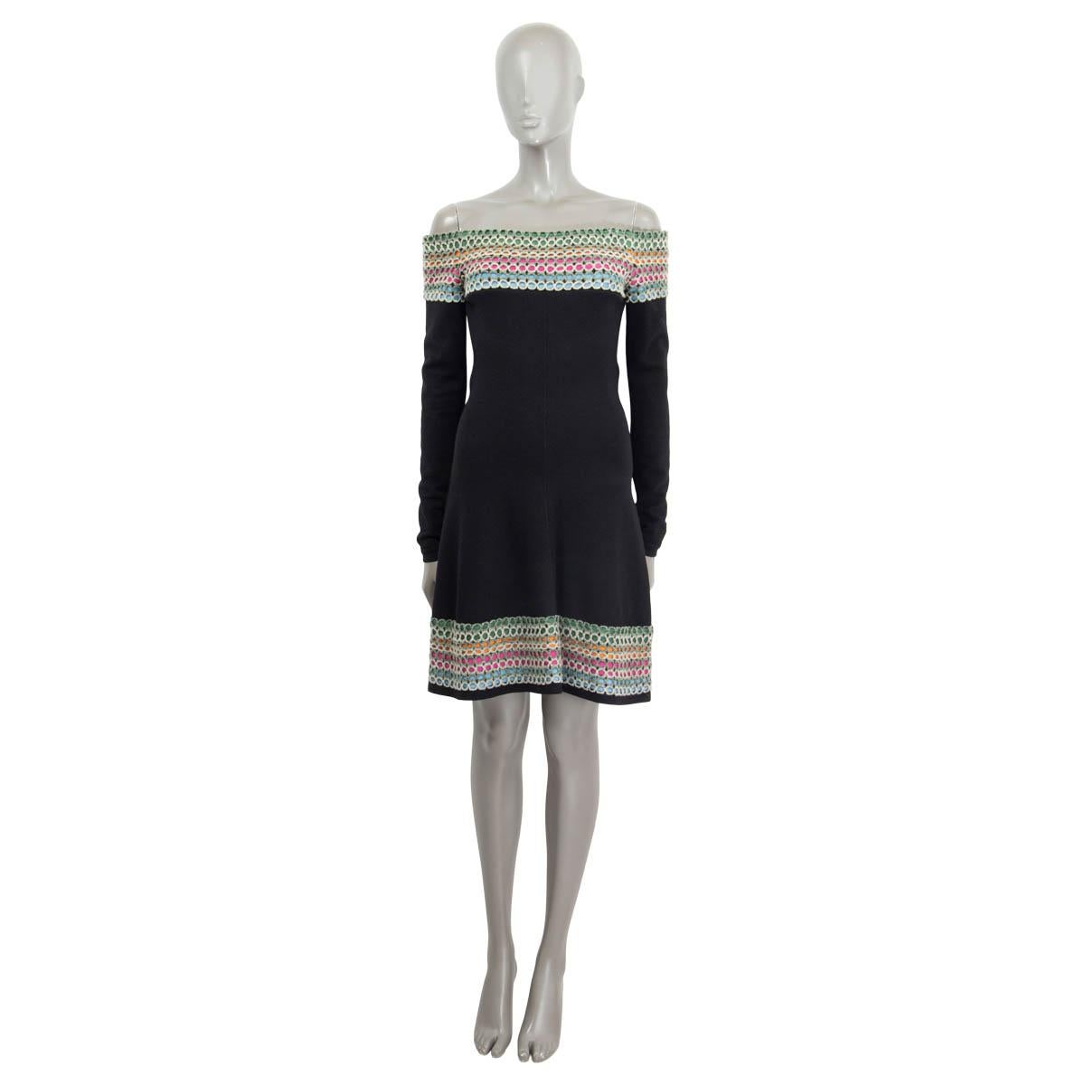 100% authentic Alaïa off-shoulder dress in black wool and polyamide (missing tag). Opens with a black zipper in the back and features knit details in pink, light blue, green, and orange. Has a flared cut on the hips and long black sleeves with knit