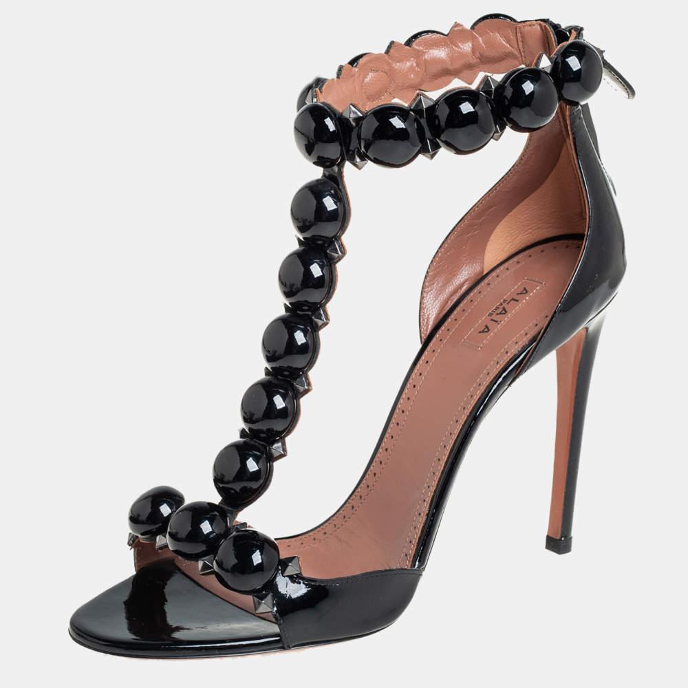 Artistically designed to adorn your feet with sheer elegance, these Alaia sandals are a must-buy! The black Bombe sandals are crafted from patent leather and feature an open-toe silhouette. They flaunt a single vamp, ankle, and a T-strap which are