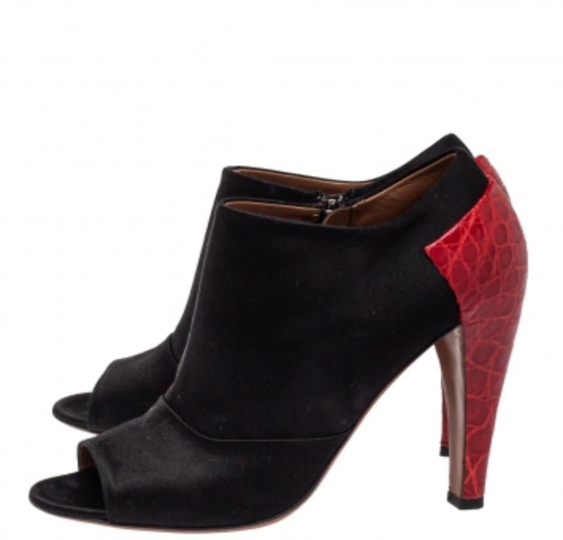 This bold yet chic pair of Alaia booties has a stylish silhouette and simple design and can be paired well with multiple outfits and looks. The booties have been crafted from satin and croc-embossed leather and feature zippers on the sides.